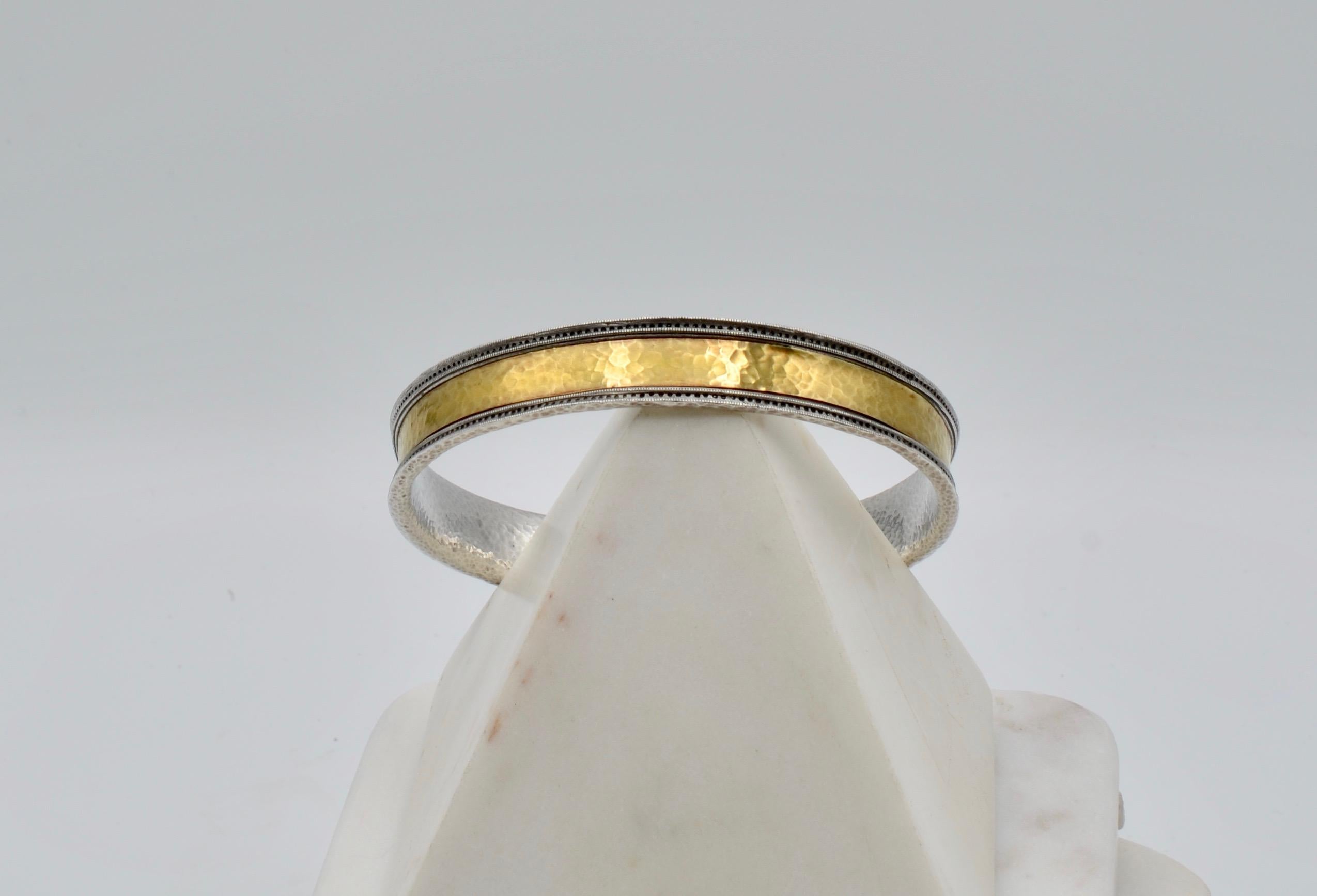 This beautifully hammered bangle bracelet is sterling silver and 22 karat gold. It is a great weight and look to wear alone or to add to you bracelet collection and layer. The outside edges have a texture that appears at first glance to be a row of