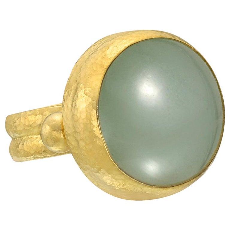 Cabochon green-hued aquamarine ring, the aquamarine measuring approximately 18mm in diameter, in hammered 24k yellow gold, signed Gurhan. Size 6.75.