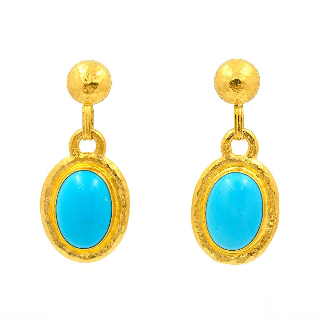 From Gurhan, these 24 karat yellow gold drop earrings feature bezel set oval turquoise cabochons. The gold has a hammered finish and the earrings have post backs.
-	24k Yellow Gold
-	Oval Turquoise Cabochons
-	Hammered Finish
-	Post Backs
-	Circa