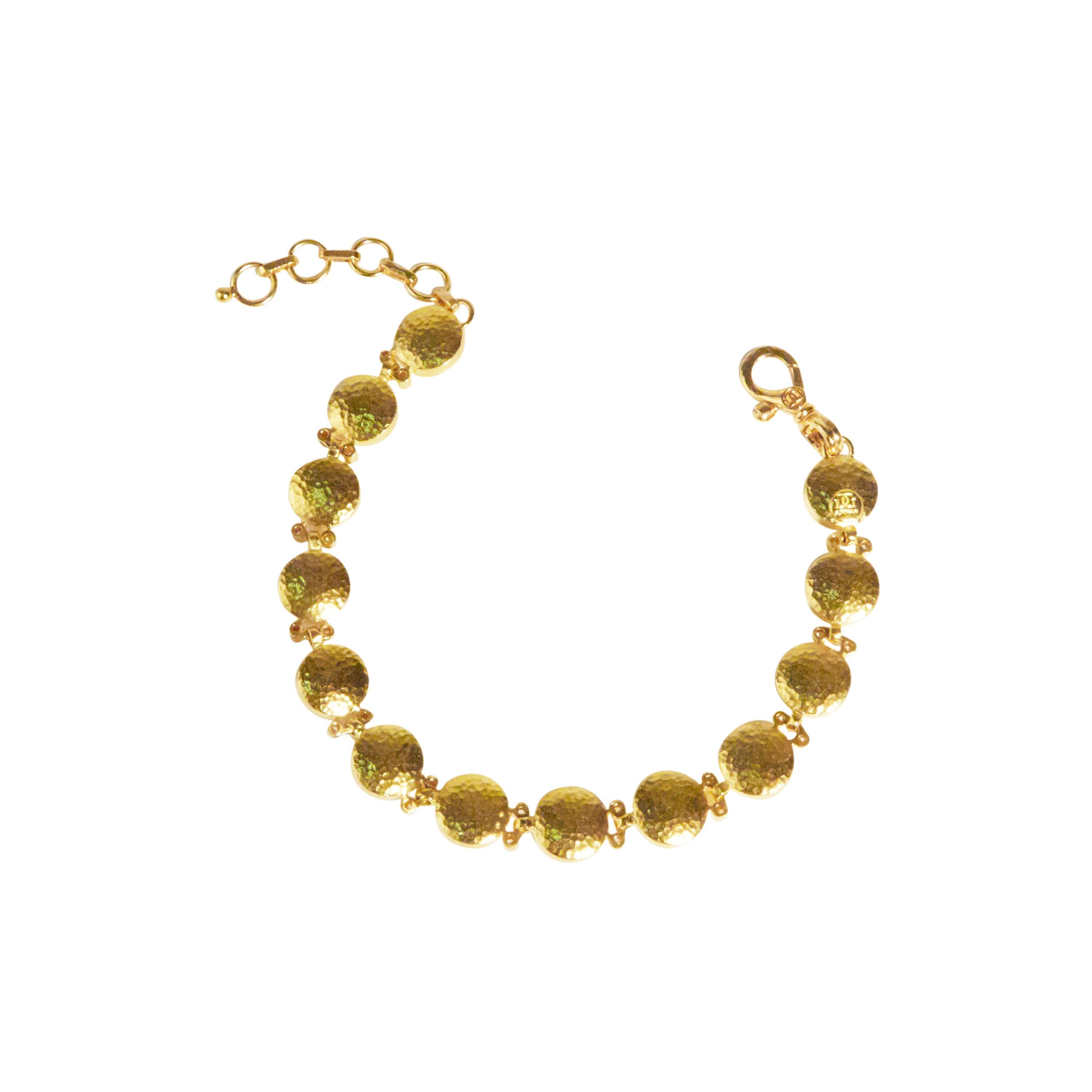GURHAN all-around 24 Karat hammered yellow gold Amulet bracelet featuring (13) 10mm round amulets and (24) brilliant white diamonds, 0.432cts., on hinged links. Adjustable length from 7.5-8.5