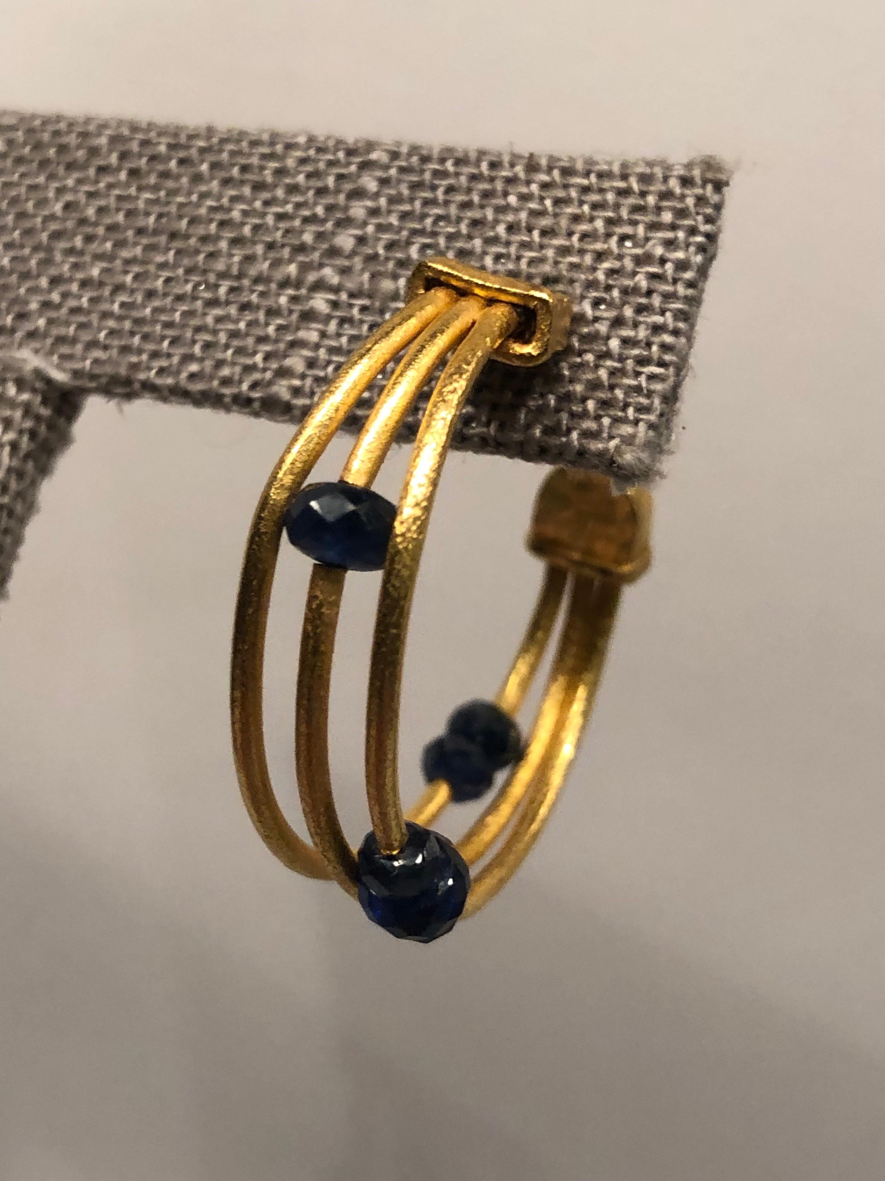 One of a kind hand forged and fabricated Gurhan gold hoops.

24k yellow gold
Dark Blue rose cut saphires
Lightly worn and in excellent condition

