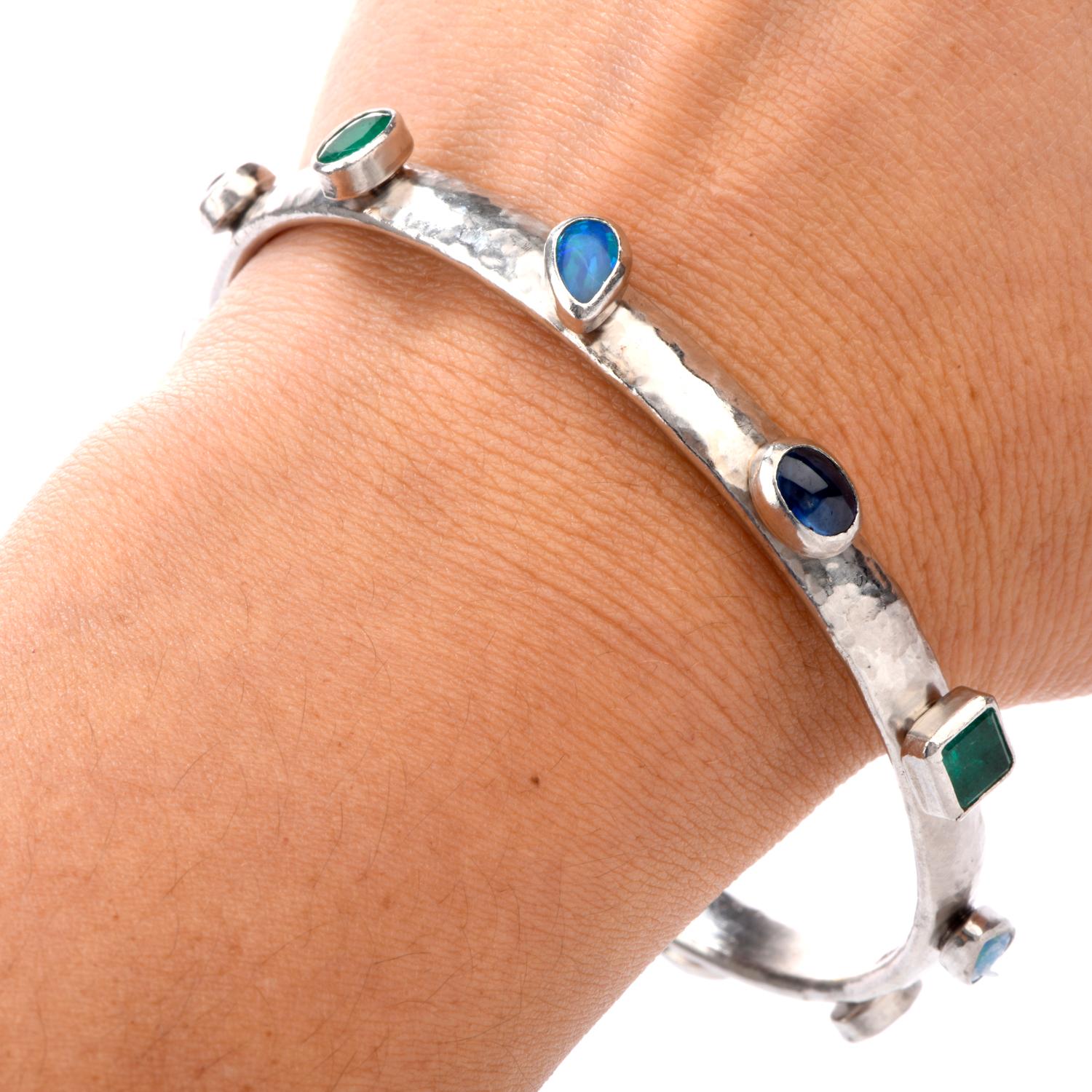 This beautifully embellished hand hammered Gurhan bracelet was crafted

in Luxurious Platinum. you can own this for fraction of its original cost.

Adorning the bangle are 4 geometrically shaped Emeralds, 3 Sapphire

and 4 Opals all bezel set onto