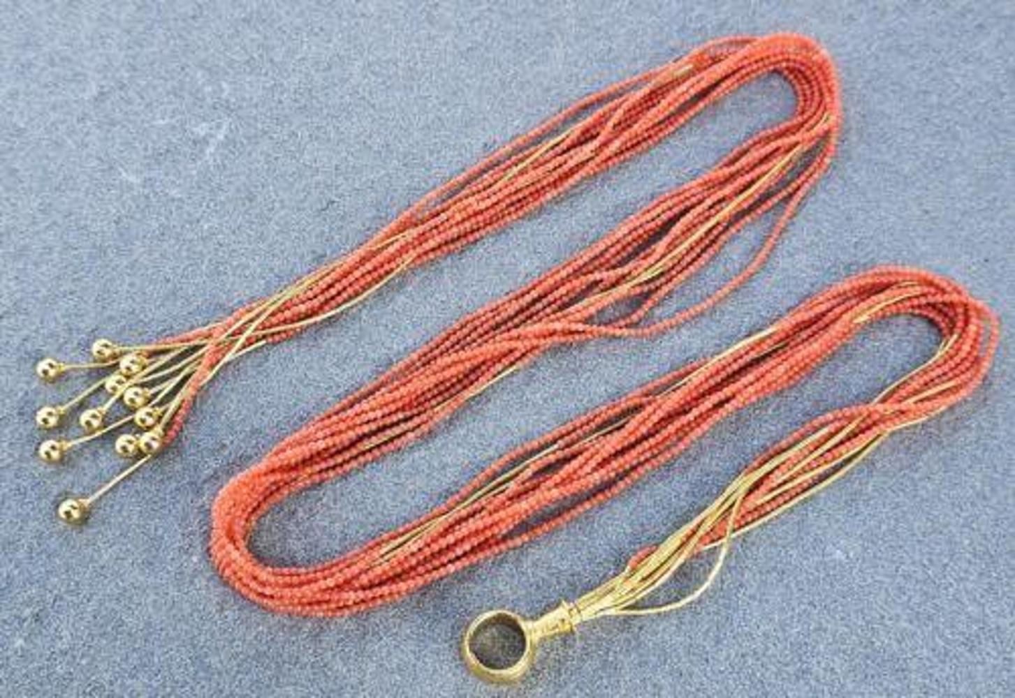 This exquisite Gurhan Rain Coral Lariat Necklace is a rare find for jewelry connoisseurs. Made with 24k yellow gold, the necklace features 12 chains and a stunning coral stones. The necklace is 28 inches long and has a beautiful orange color,