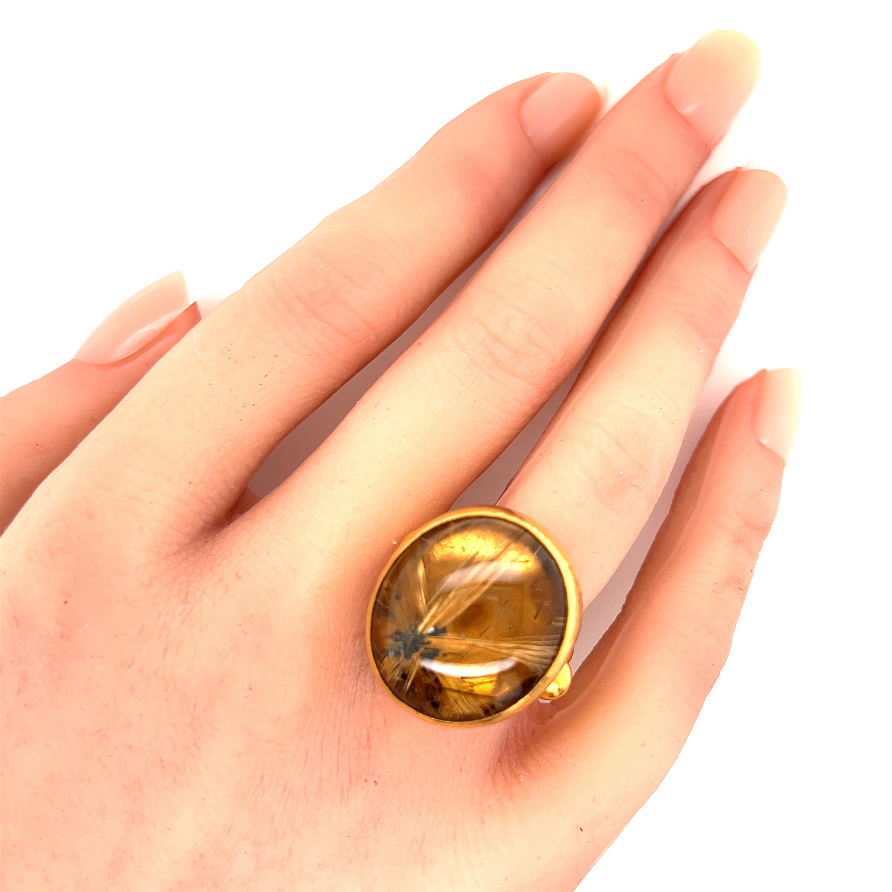 Questo splendido anello è di Gurhan, della collezione Rune. È realizzato in oro 24k con una raffinata finitura martellata intorno all'ampio ponte ovale e al gambo scanalato. La parte centrale superiore presenta una pietra di quarzo rutilato marrone