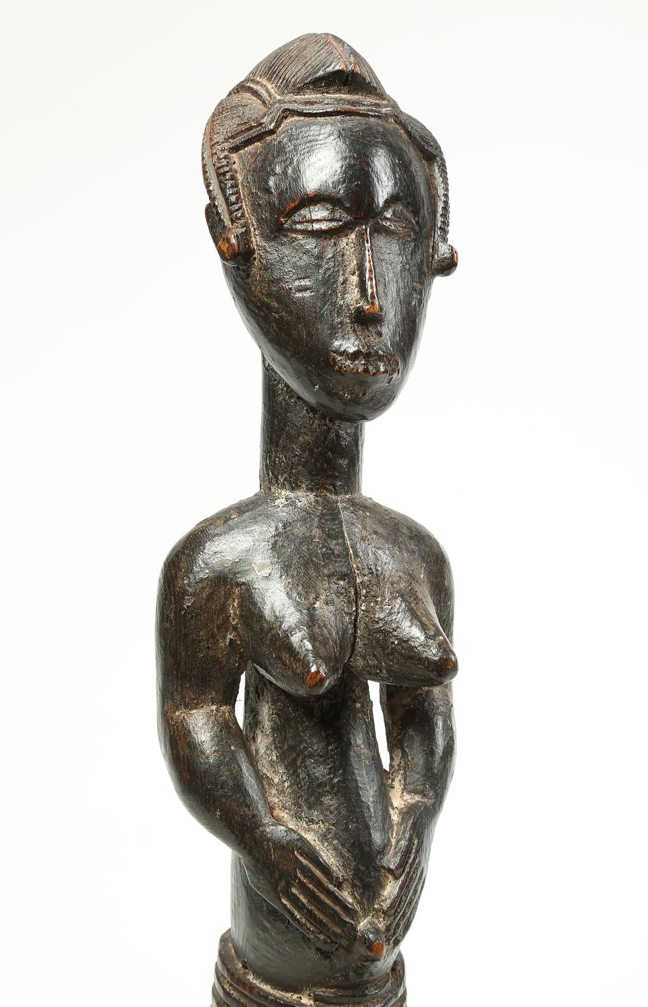 Finely carved female figure, Guro people, Ivory Coast Africa (Cote d'Ivoire), West Africa. Created in the early 20th century. Classic standing female figure with finely carved face and features and delicate hair braids down each side of face. Deep