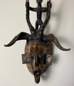 Guro Style African Carved Wood Horned Antelope Mask with Figure, Côte d’Ivoire