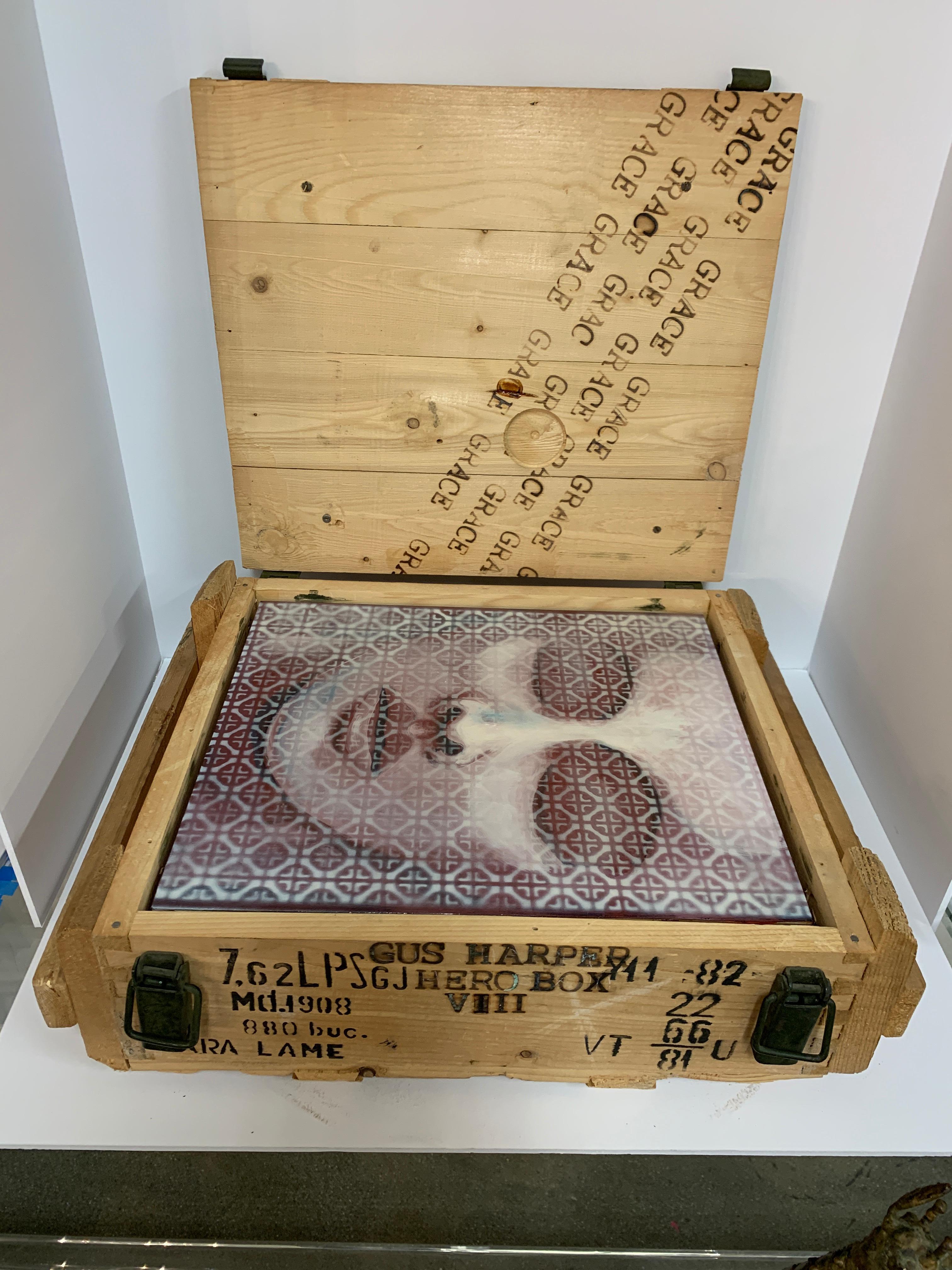 A nice installation package by the noted California artist Gus Harper. This work dates to the early 2000s from a show called fade to white. It is encased in an old wooden ammunition box and features an original work of art. It is burned on the