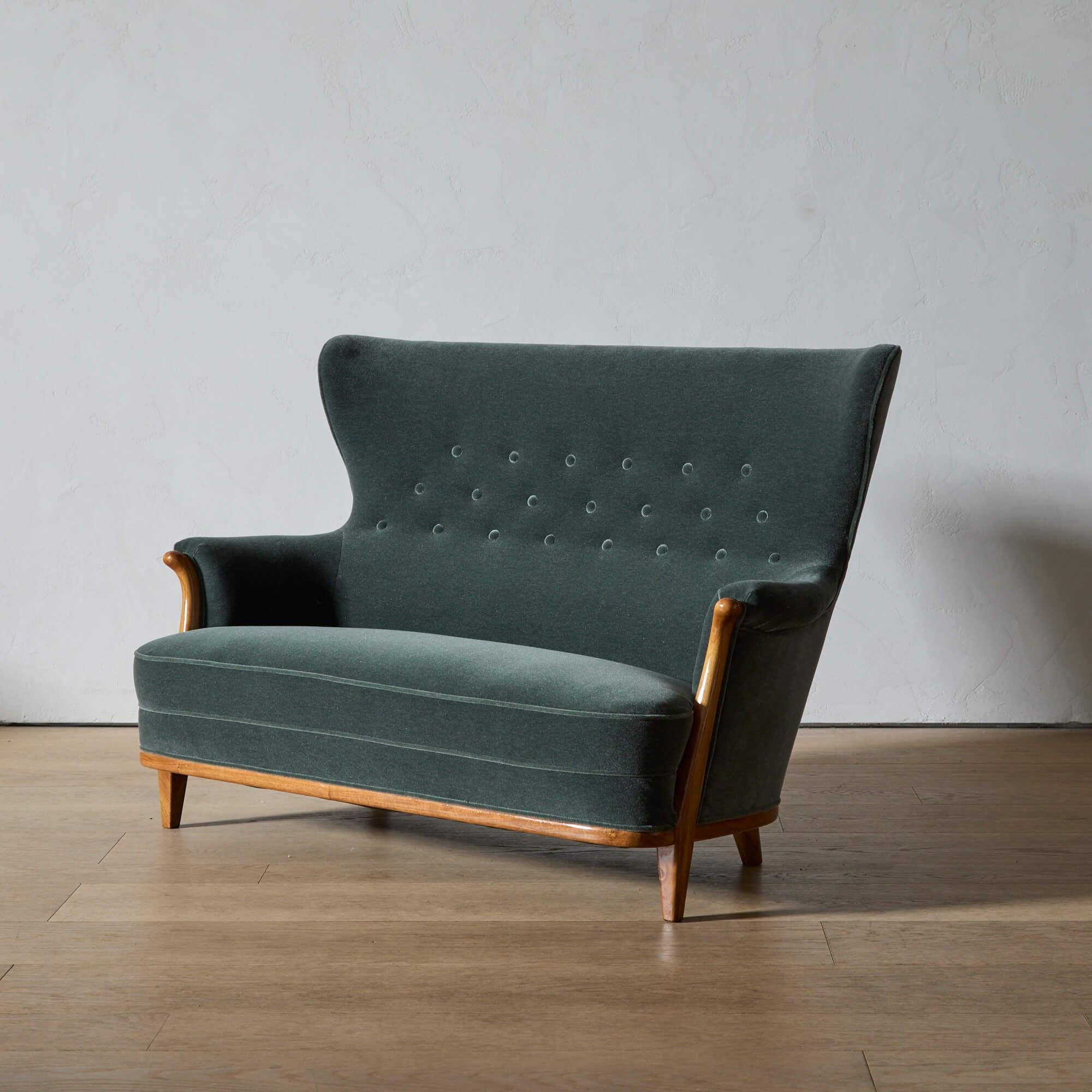 Ein elegantes Flügelsofa von Gustaf Allert, neu gepolstert mit anthrazitfarbenem Mohair-Samt. Die hohe, mit Knöpfen versehene Rückenlehne und der sichtbare Nussbaumrahmen sind eine ungewöhnlich raffinierte Interpretation eines klassischen Designs.
