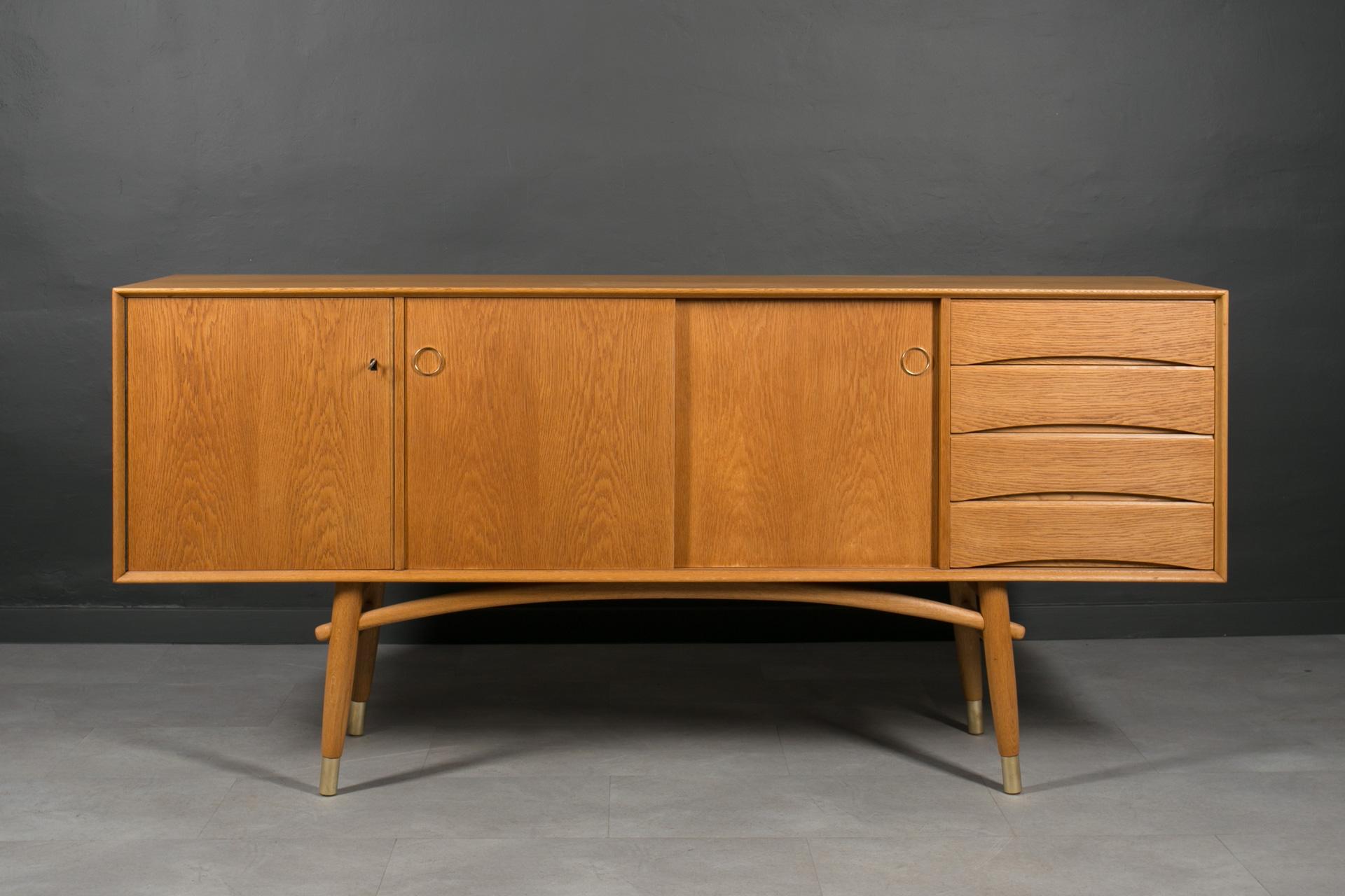This exquisite sideboard is a true masterpiece designed for Gustav Bahus Furniture manufacture around 1950s. This extraordinary piece seamlessly blends beautiful Scandinavian design and function, making it a must-have for discerning connoisseurs.