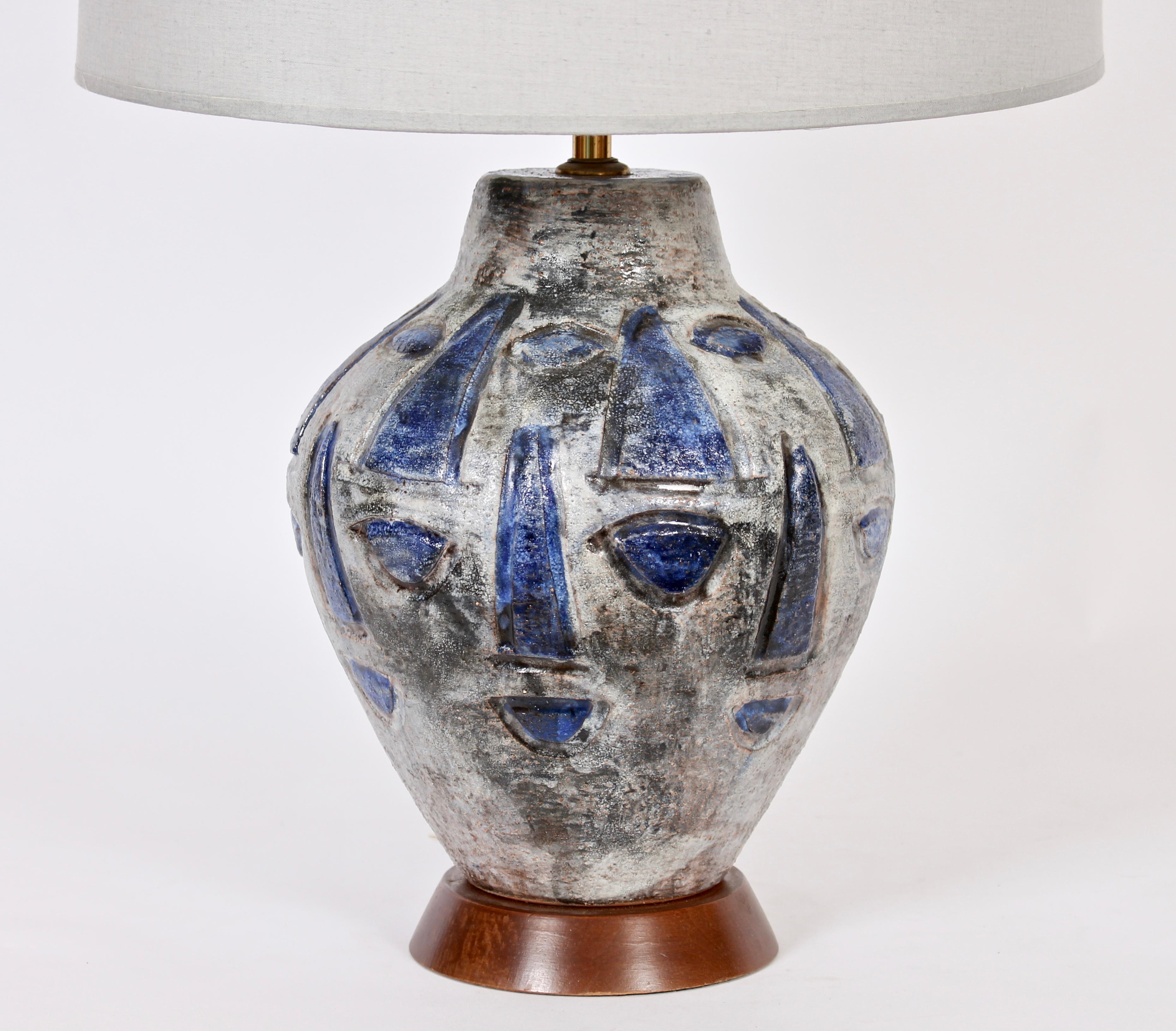 Gustav Spoerri hand painted glazed ceramic art studio table lamp. Featuring a hand crafted sculptural jug form in neutral gray highlighted abstract design lined in black with bright blue oval and triangular shapes. On walnut base. 17 H to top of
