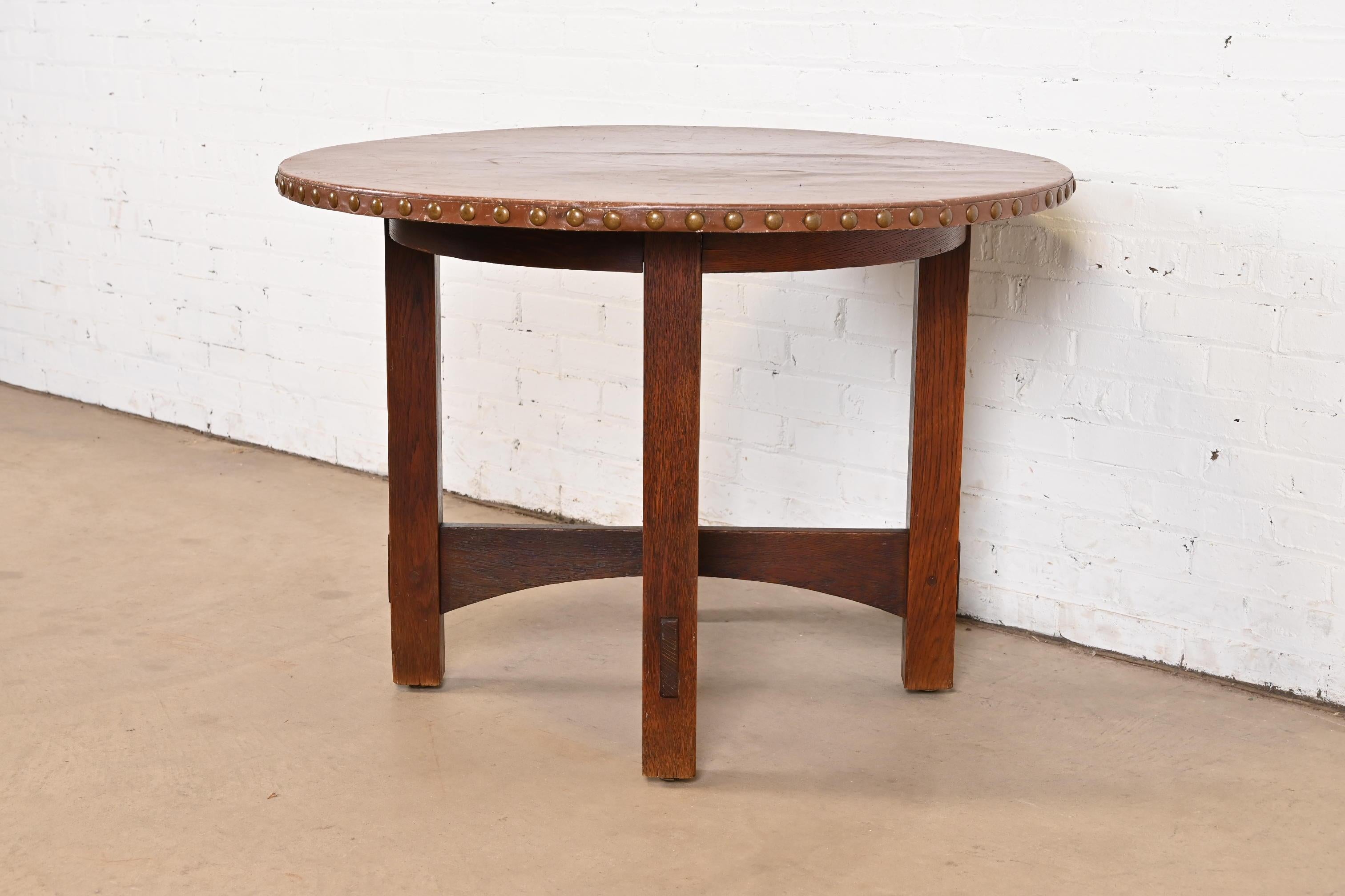 A gorgeous antique Mission or Arts & Crafts center table or breakfast table

By Gustav Stickley (signed with red decal)

USA, Circa 1900

Solid quarter sawn oak, with leather top.

Measures: 40.25