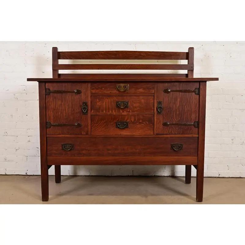 Un'eccezionale credenza, un buffet o un mobile bar con portapiatti d'epoca Mission o Arts & Crafts.

Di Gustav Stickley

USA, circa 1910

Quercia segata in quarto, con ferramenta originale in rame martellato. L'armadio si chiude a chiave e la chiave