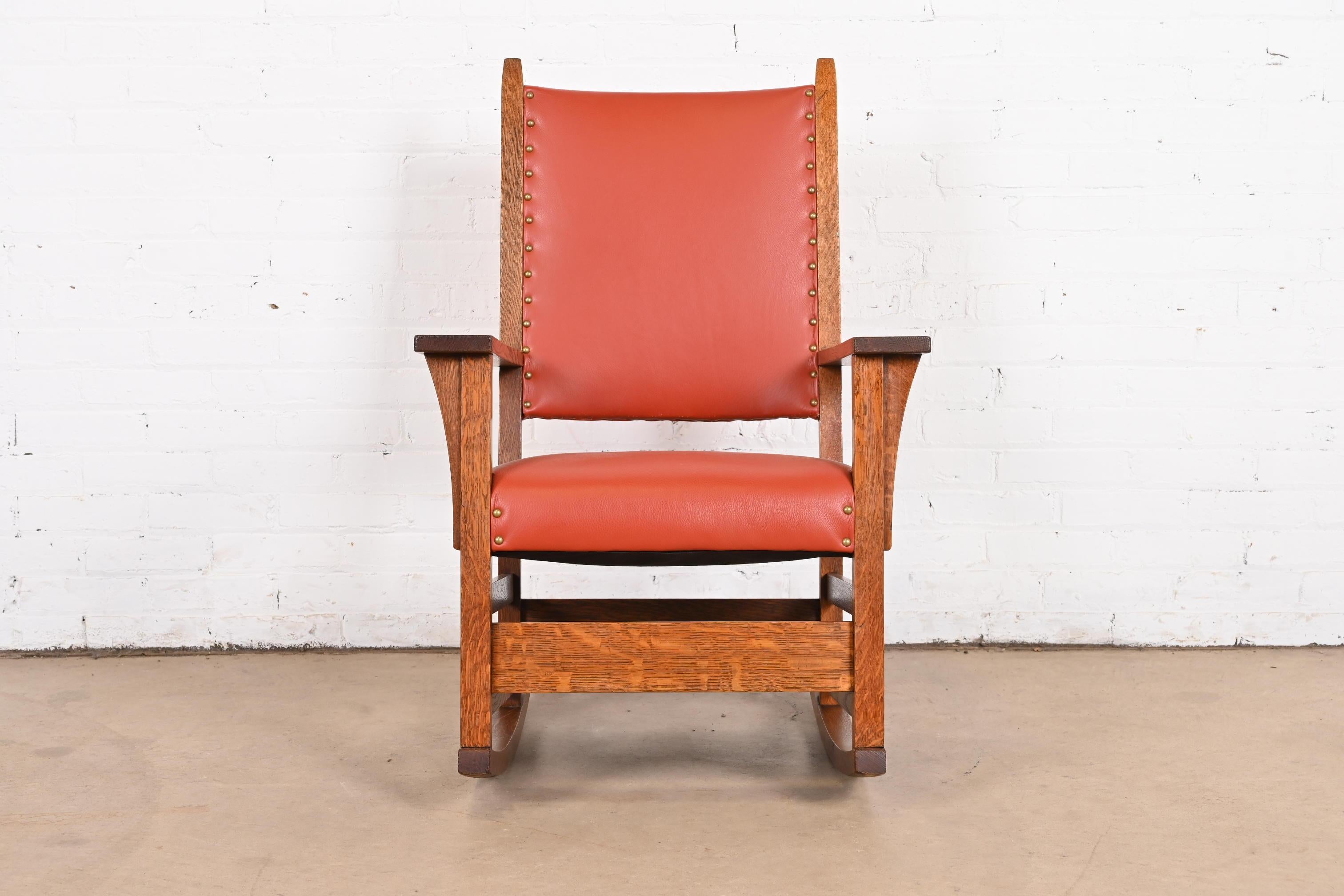 Un magnifique fauteuil à bascule Arts & Crafts en chêne Mission

Par Gustav Stickley

USA, Circa 1900

Chêne massif scié sur quartier, avec assise et dossier en cuir clouté de laiton.

Dimensions : 25,5 