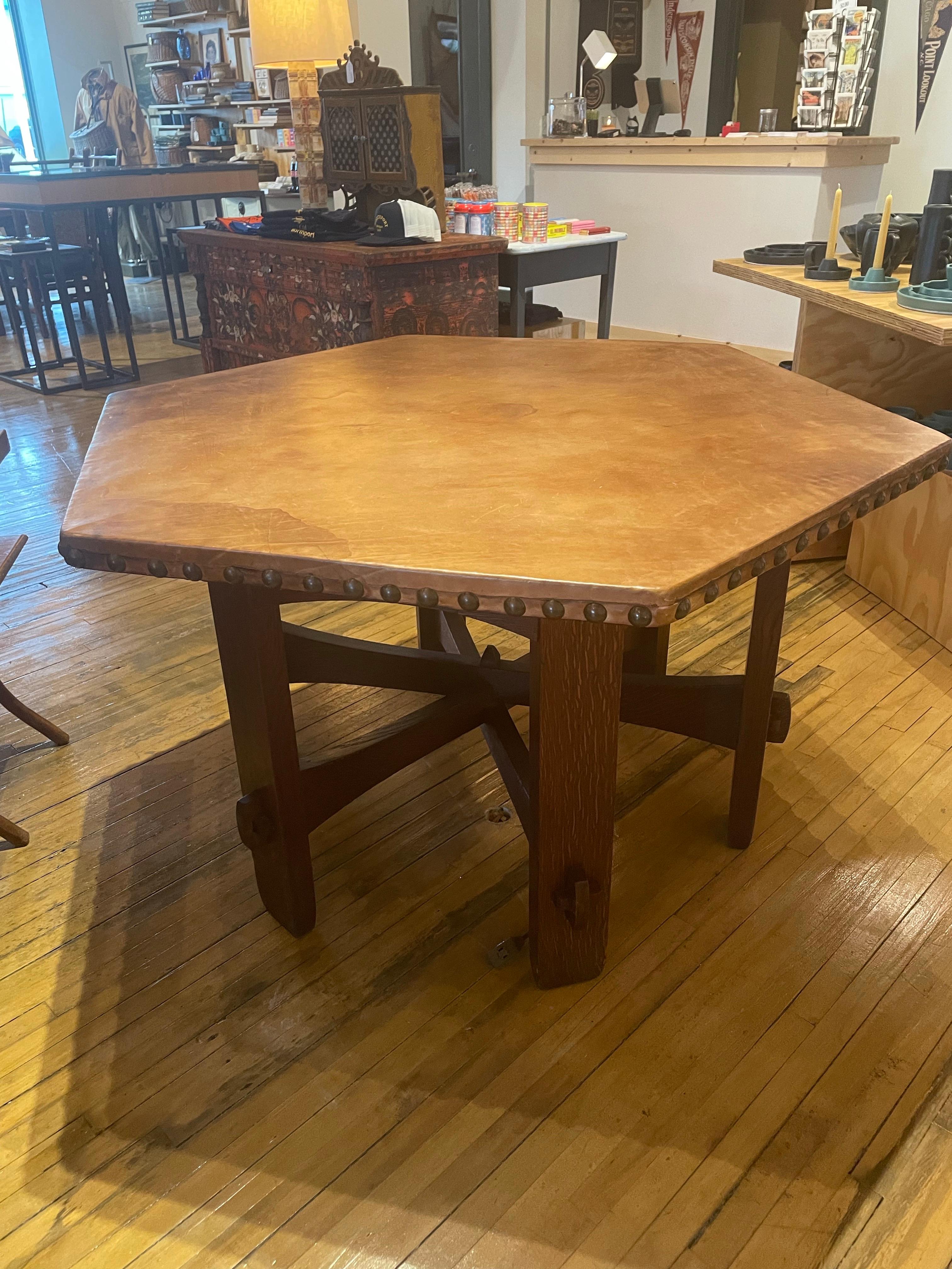 An exceptional example of early American Arts and Crafts design, this rare hexagonal library table by Gustav Stickley dates to circa 1902. Crafted in solid quarter-sawn oak with a warm, aged patina, the piece features hallmark construction