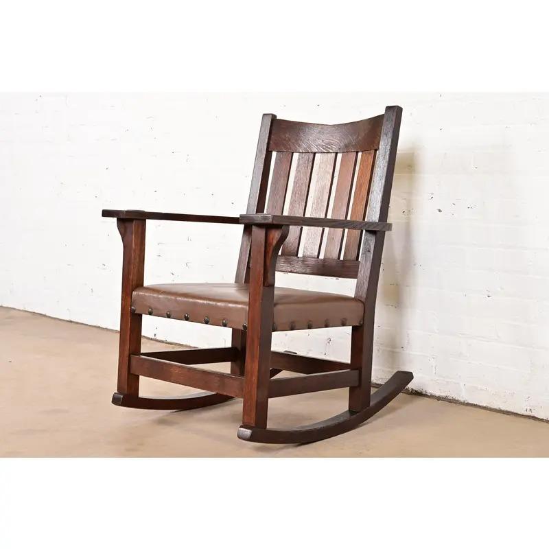 Una splendida sedia a dondolo con schienale a V di epoca Mission o Arts & Crafts

Di Gustav Stickley

USA, circa 1910

In legno massiccio di Oak, con seduta imbottita in pelle marrone.

Misure: 26 