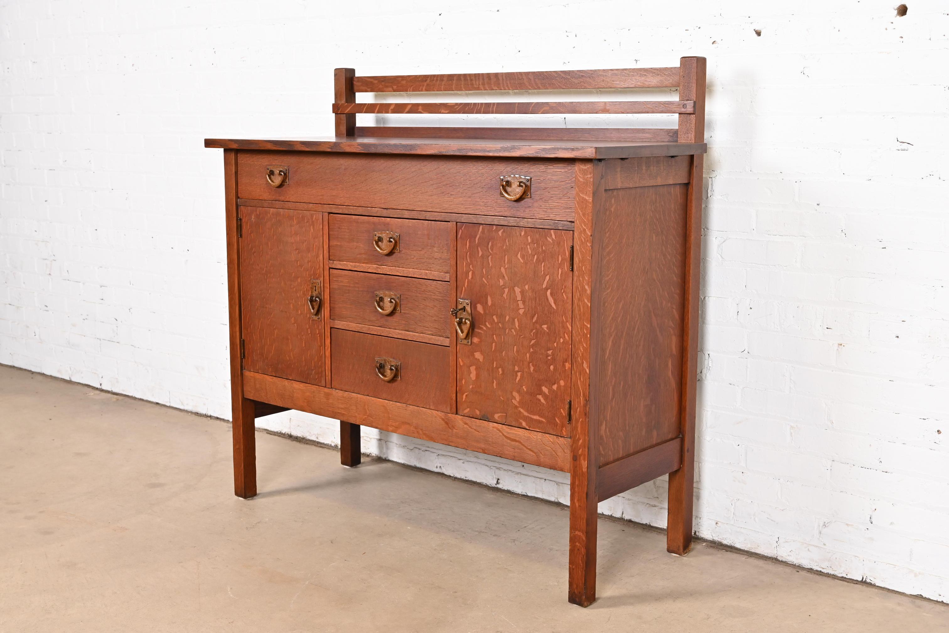 Rare et exceptionnel buffet ou meuble de bar ancien de style Mission ou Arts & Crafts avec porte-assiettes.

Par Gustav Stickley

USA, Circa 1900

Chêne scié sur quartier, avec quincaillerie d'origine en cuivre martelé. L'armoire se verrouille et la