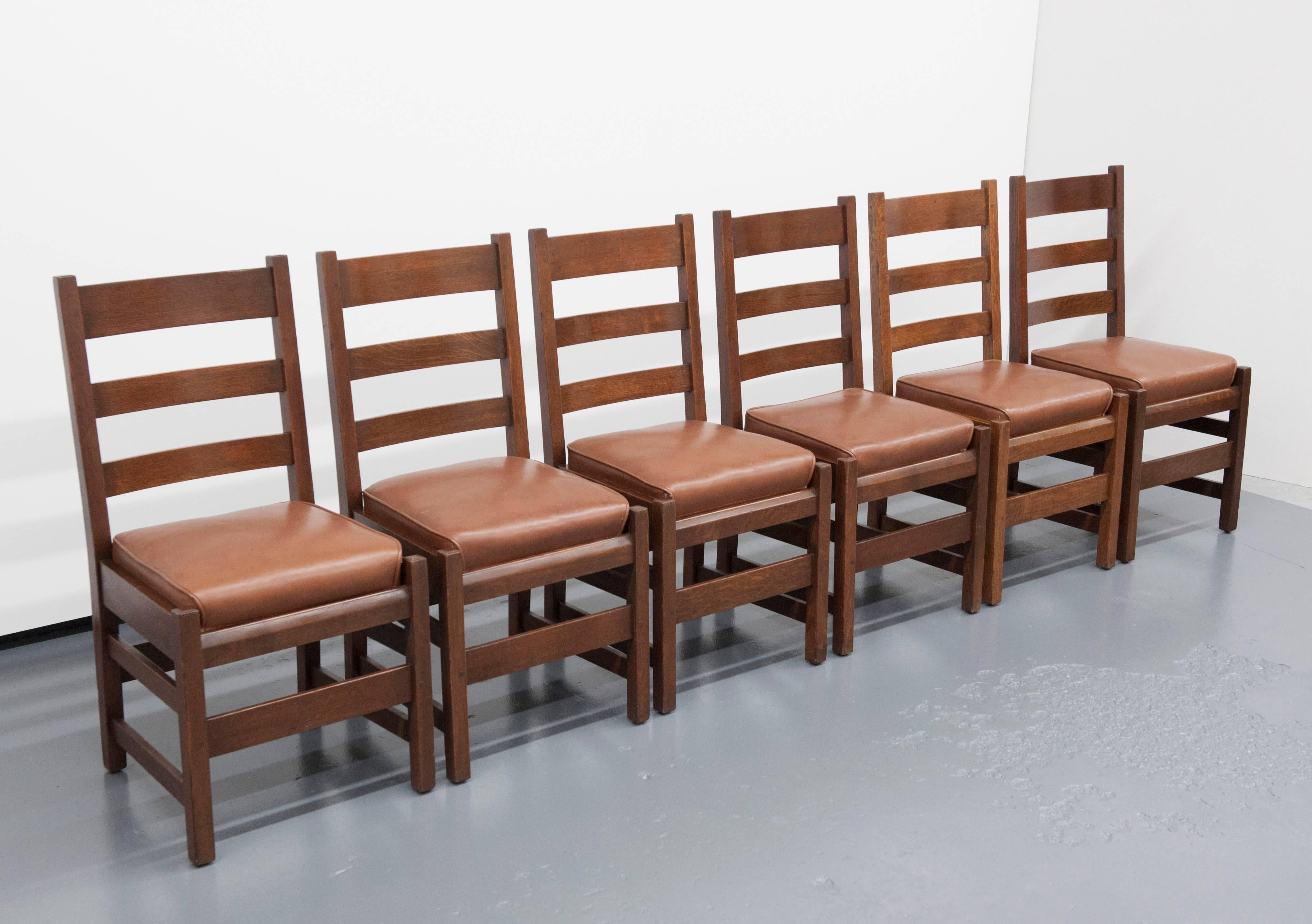 1905 Gustav Stickley designed set of six side chairs. Exceptional quality with original inner sprung leather seats. Solid oak construction with only light signs of use. Label shows chairs were made between 1916-1919. Price is for set of six chairs.
