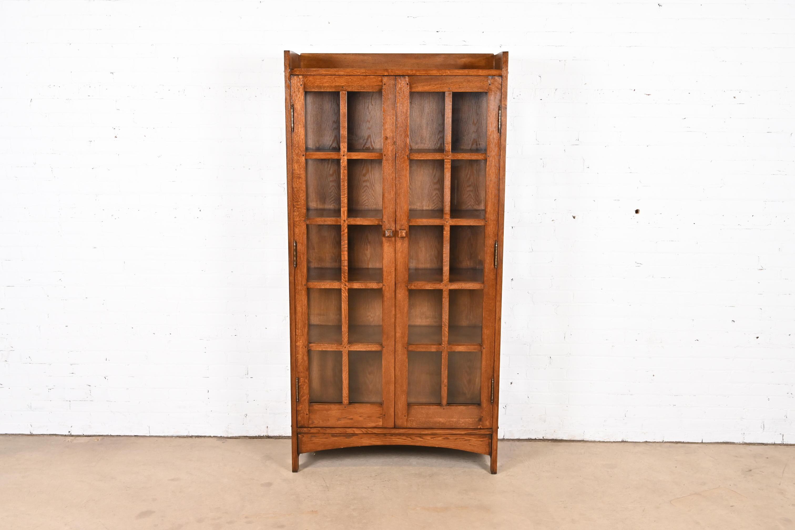 A beautiful Mission or Arts & Crafts style bookcase cabinet

In the manner of Gustav Stickley

USA, Circa Late 20th Century

Solid oak, with mullioned glass front doors and sides.

Measures: 39.25