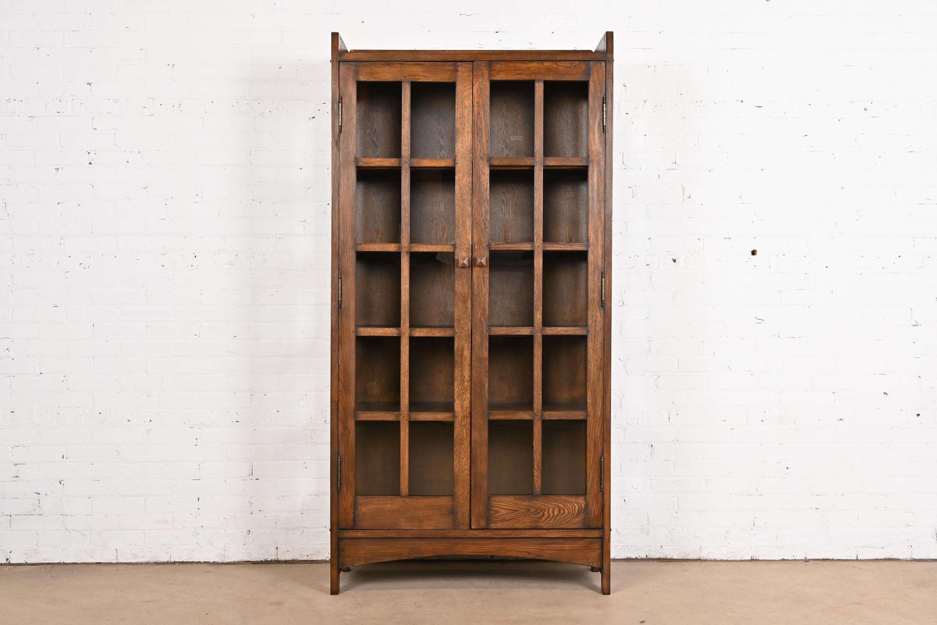 A beautiful Mission or Arts & Crafts style bookcase cabinet

In the manner of Gustav Stickley

USA, Circa Late 20th Century

Solid oak, with mullioned glass front doors and sides.

Measures: 40