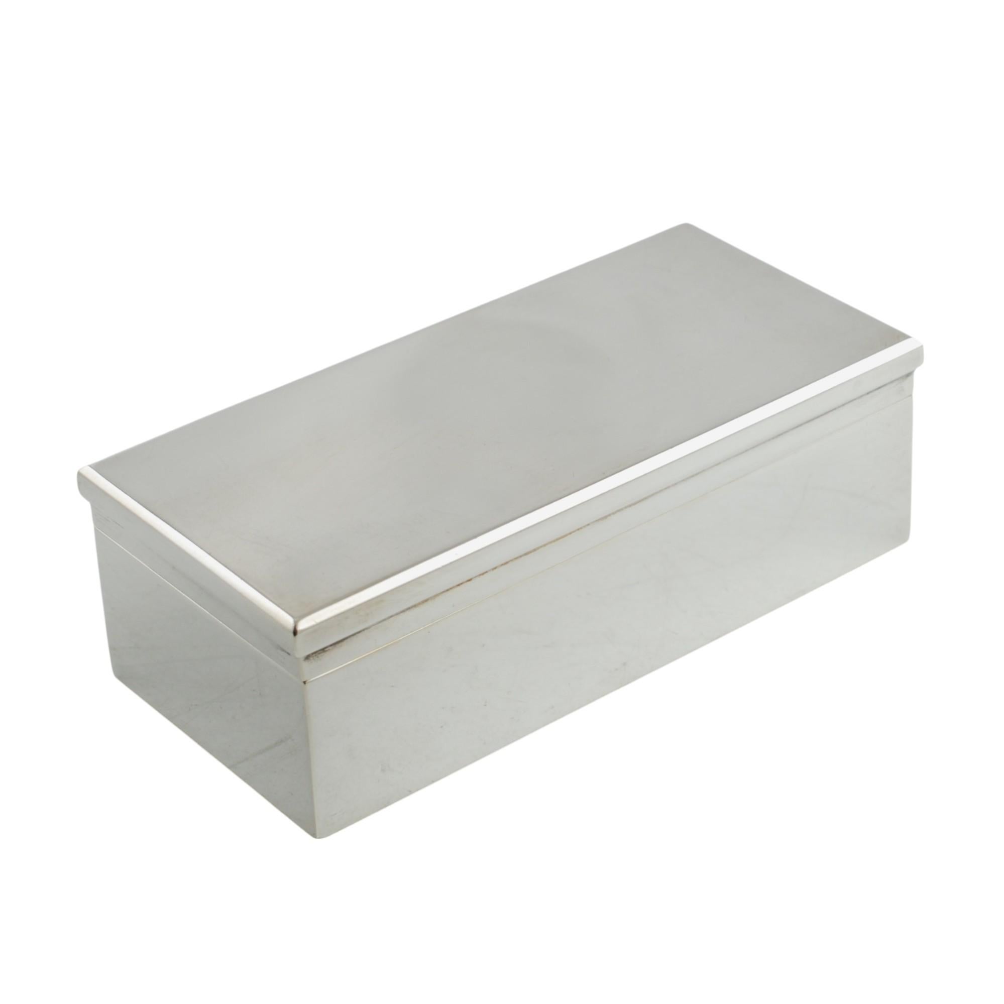Ce coffret rectangulaire Art déco en argent massif a été réalisé par l'atelier parisien du bijoutier et orfèvre Gustave Keller Frères.  Le coffret de la commode présente des lignes simples et élégantes, sans ornementation, et n'a pas été