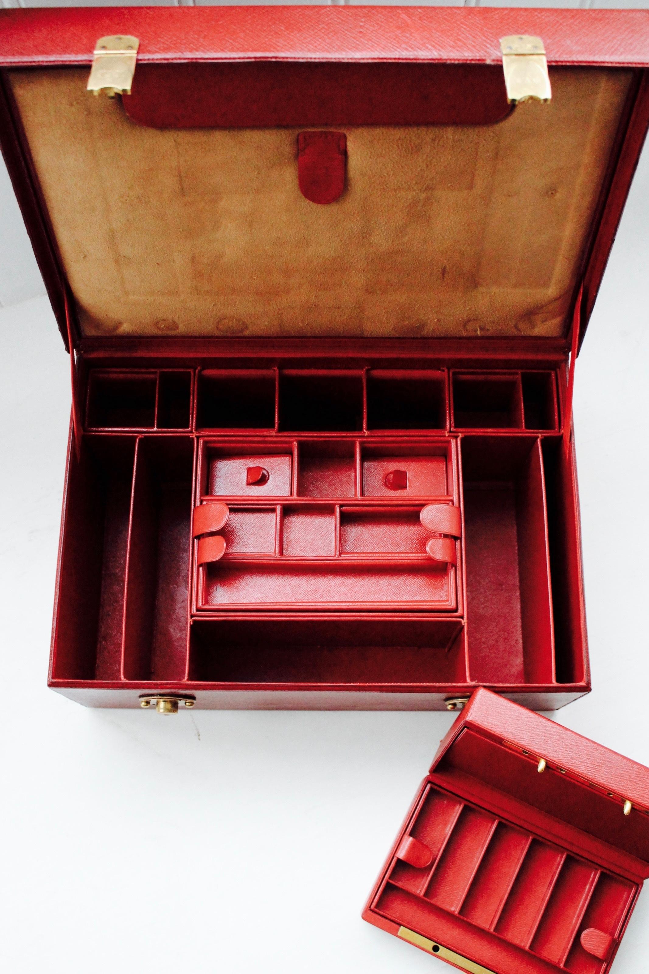 Un beau coffret à bijoux/écritoire en cuir français par Gustave Keller, Paris, vers les années 1920, maroquin rouge, écussons et ferrures dorés, l'intérieur équipé d'un coffret à écrire dans le couvercle, de plateaux à bijoux ajustés et d'un coffret