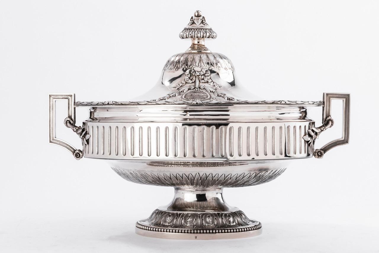 Silversmith Gustave Odiot, large terrine of ceremonial silver, 19th century
Large oval-shaped ceremonial terrine, in sterling silver, resting on a beaded and leafy pedestal, the body with fluted decoration is flanked by two geometric handles, the