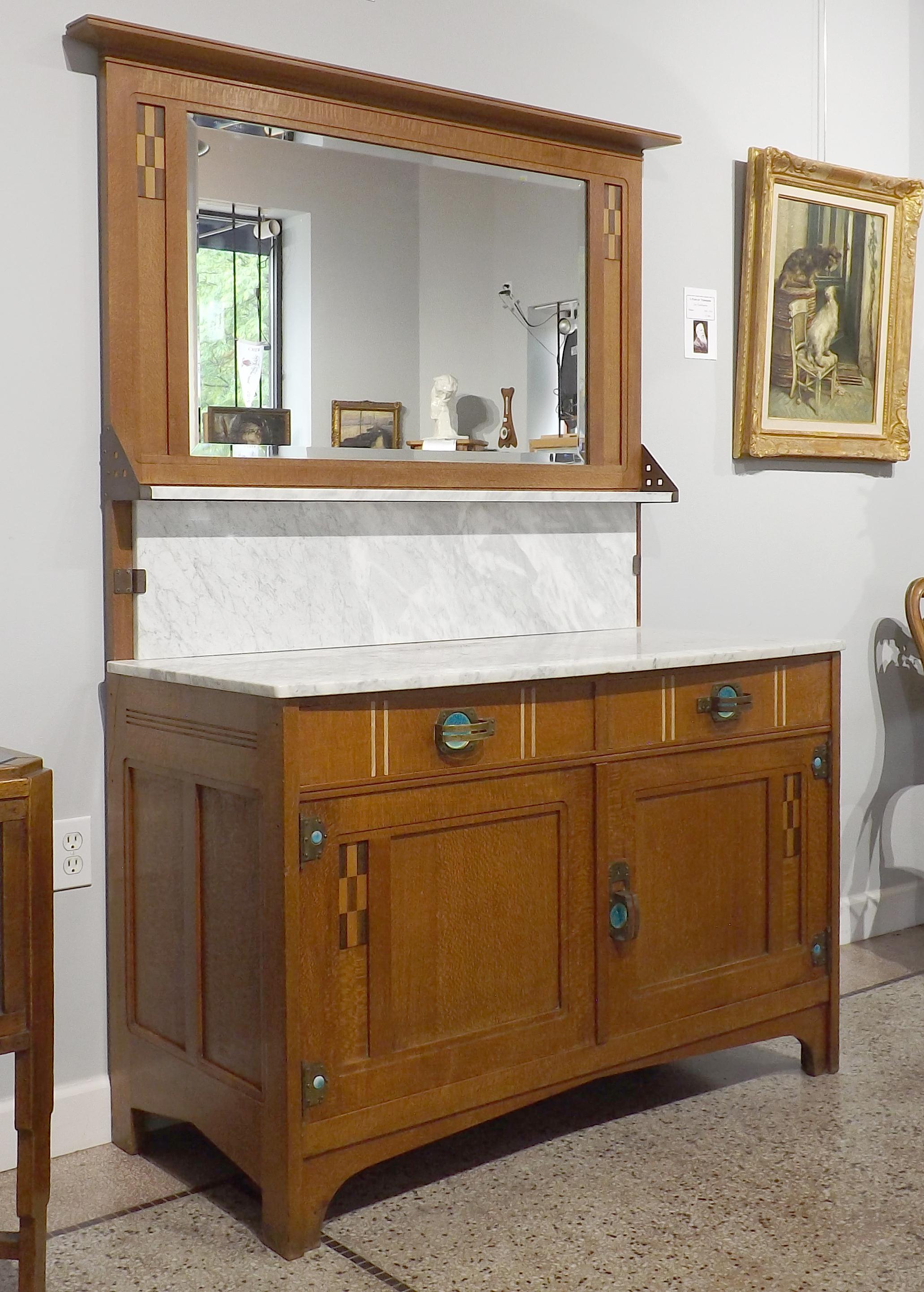 A stunning marble top vanity by the Belgian designer Gustave Serrurier-Bovy, with copper hardware and blue-green enameled medallions. A checkerboard pattern flanks the beautiful beveled mirror. Works by Serrurier-Bovy can be found in many museums