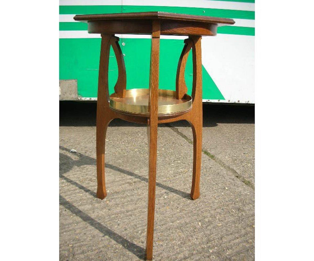 Gustave Serrurier-Bovy Style Off. 
Tavolino secessionista in Oak con piano a sei lati e ripiano inferiore circolare legato in ottone con supporti organici passanti.
Misure: Altezza 31 1/2