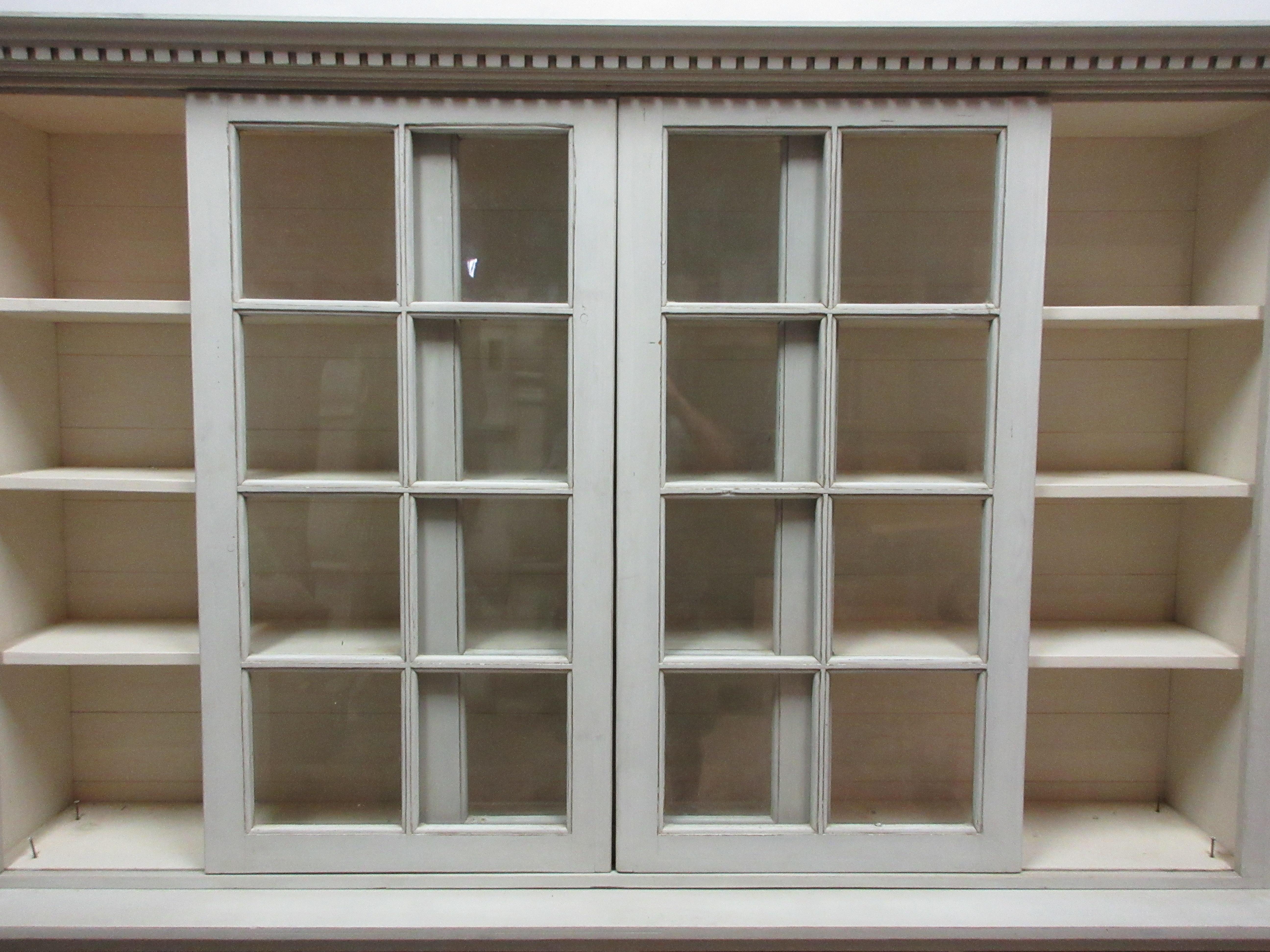This is a unique Gustavian 3-door glass top hutch. The center door is stationery and both the left and right door rolls back and forth.
