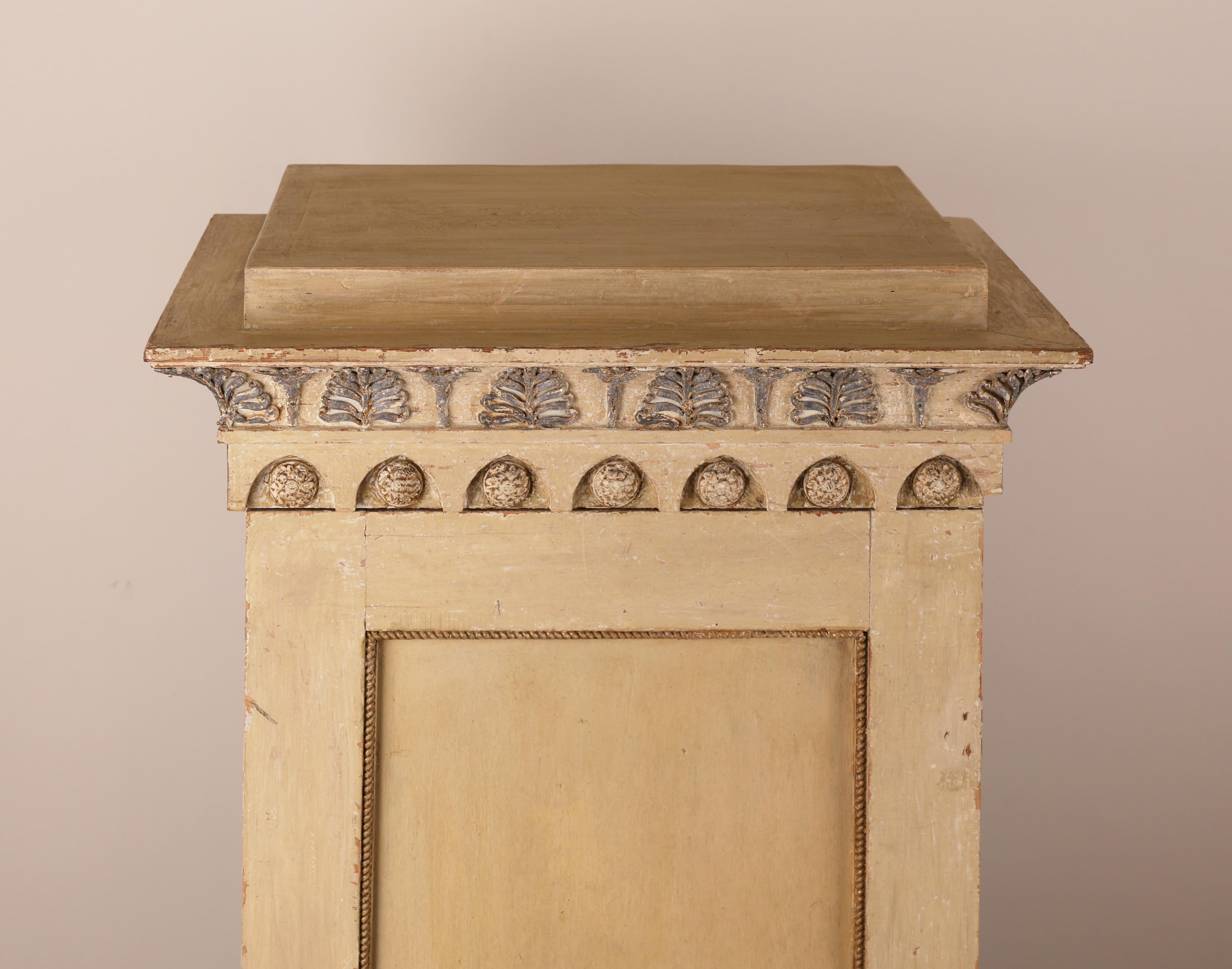 A late Gustavian column cabinet from 1810. The cabinet features crowned, profiled cornices. Each side is adorned with blue-painted Medusa heads. It opens with the accompanying key, revealing an interior fitted with two shelves, also painted in