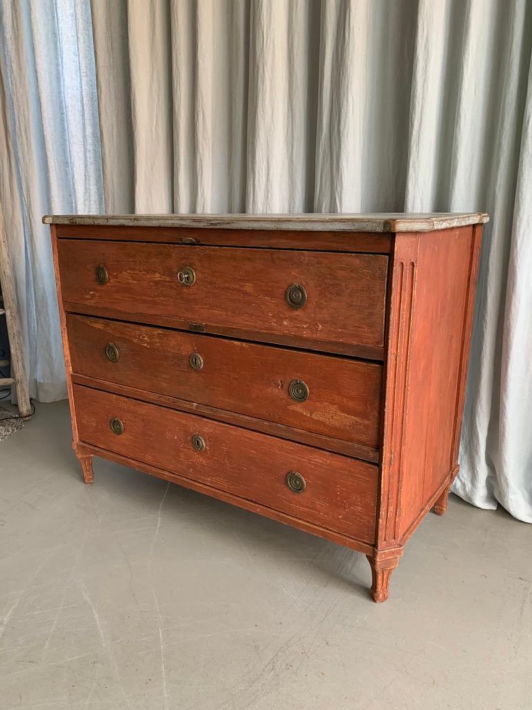 Antique Swedish Gustavian dresser or chest of drawers with 3 large drawers and with the original red paint and marbled top. The dresser has been scraped back to the original coat of paint.