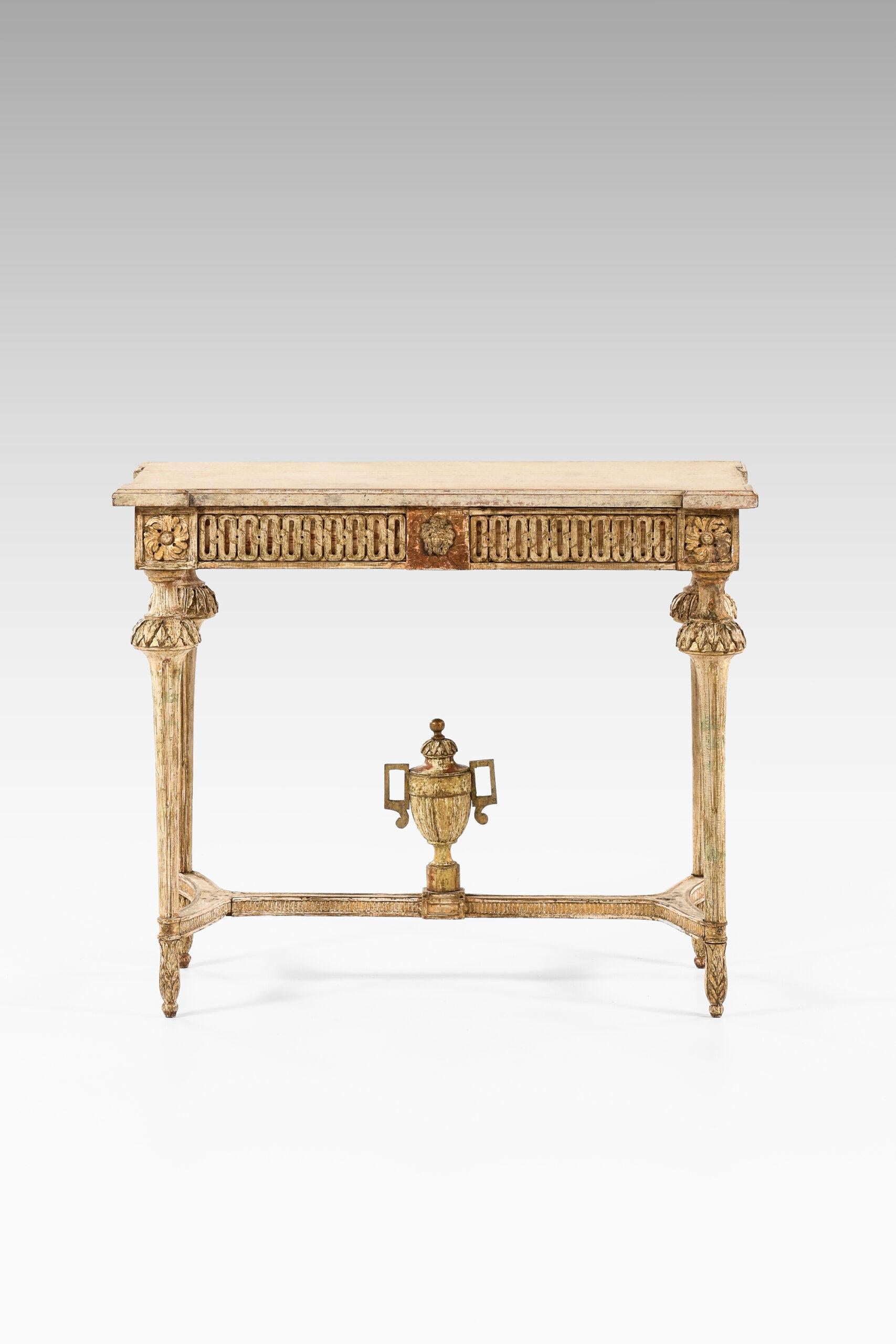 Gustavian console table. Produced in Sweden, probably in Stockholm.
Gilt wood with rich carvings with typical attributes including fluted legs, fleurons, leaves and foot cross with a classical urn. Original table top.