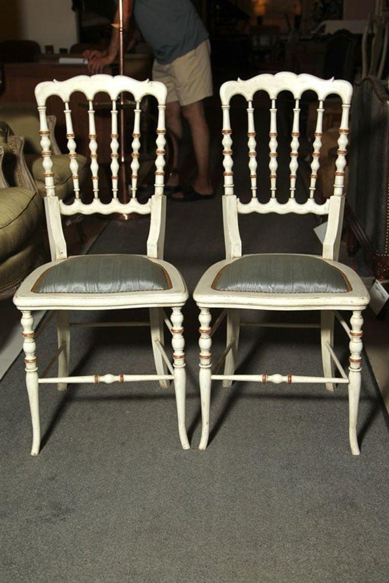 Gustavian, Dining Chairs, Spindle Back, White Paint, Giltwood, Blue Fabric
 
Set of 5 white distressed paint decorated and gilt gold Gustavian Style side chairs. Each seat with new upholstery and tacks. Price is for one chair only, please call to