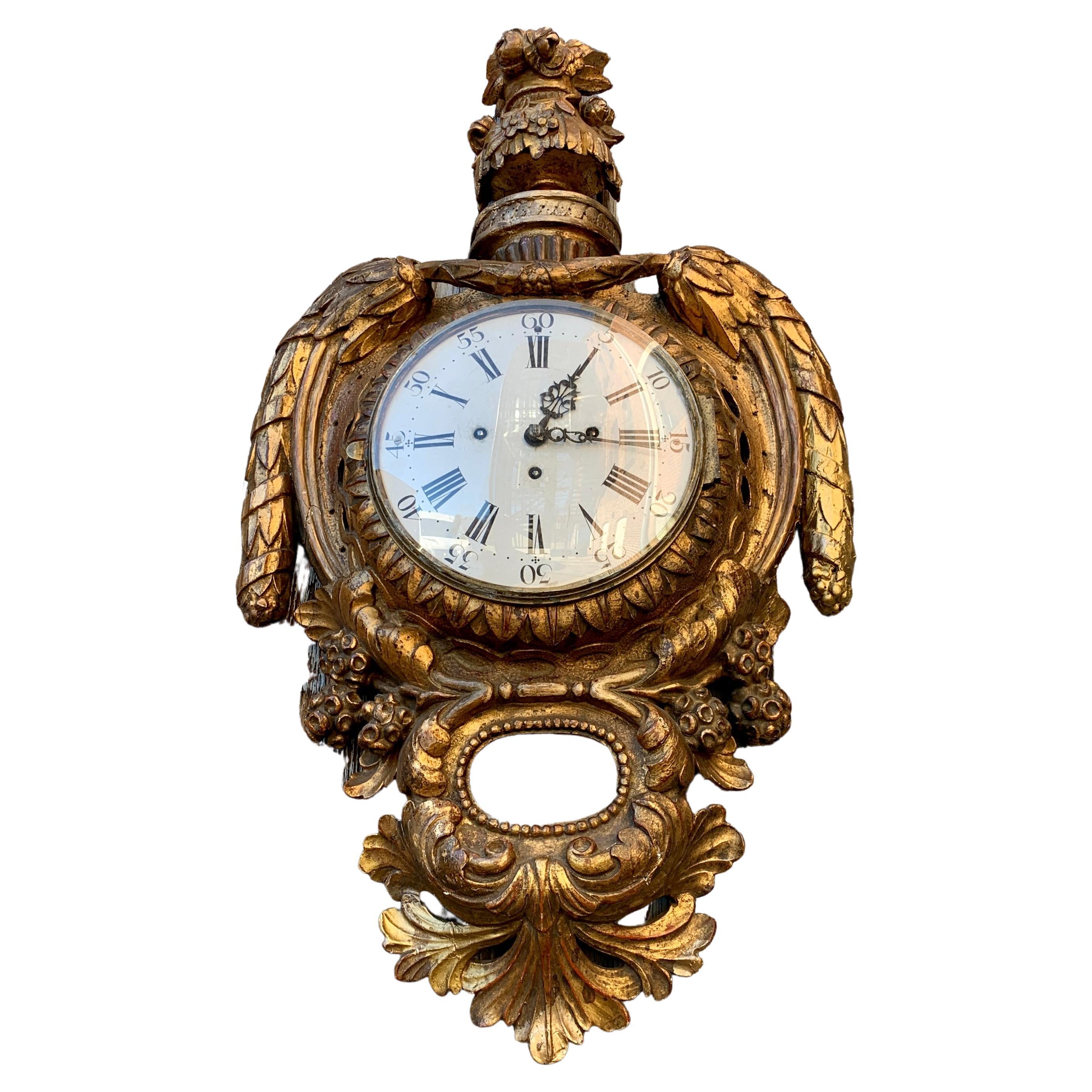 An early 19th Century Swedish Gustavian period gilded wall clock of large dimension. This richly hand carved Scandinavian giltwood clock has been professionally revised and it is in working conditions. The key to reload the mechanism is following