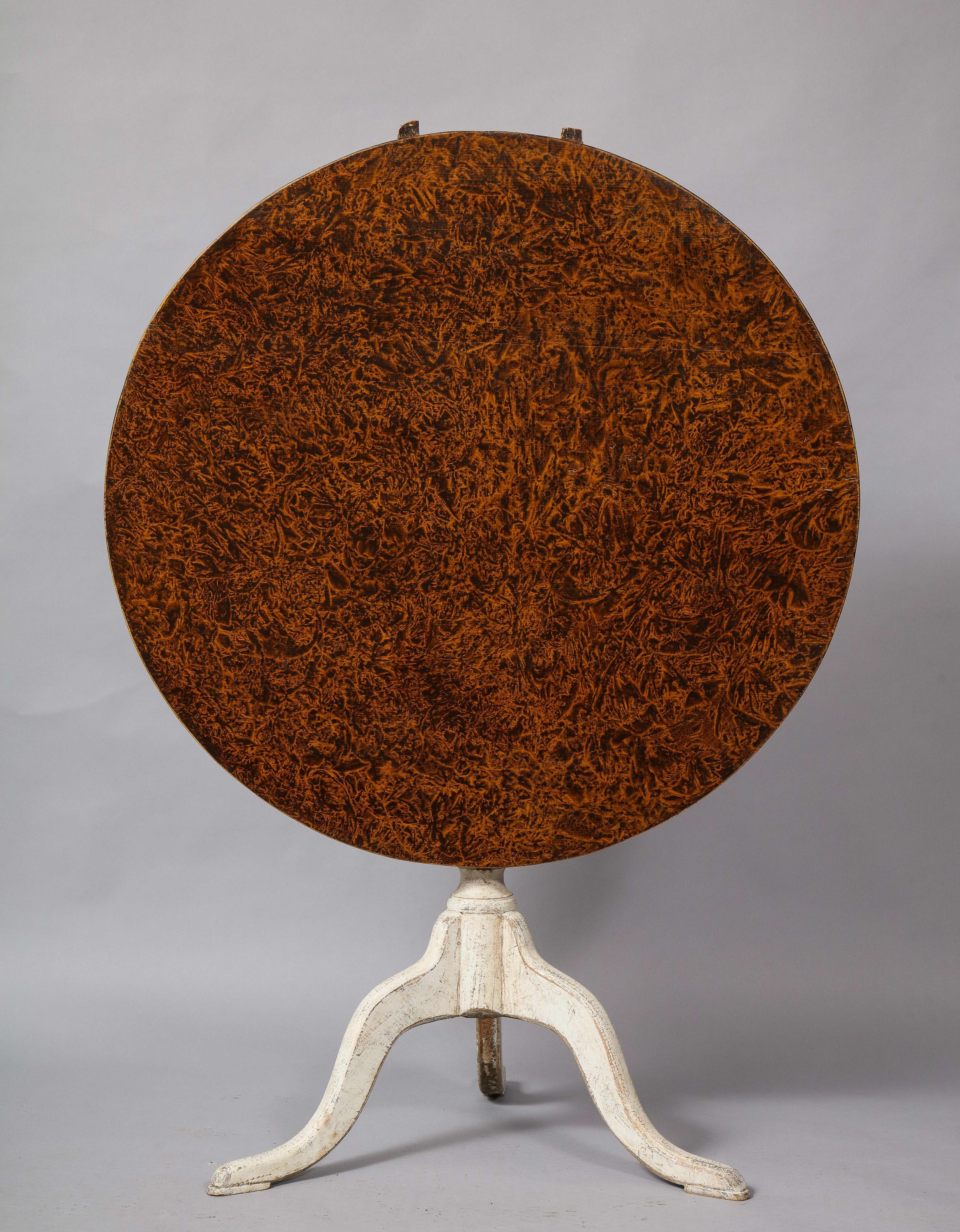 Good Swedish early 19th century tilt top tripod table with original paint decoration, the top with scumble paint resembling burr alder or burl birch grain over chalky white painted base with turned shaft and gracefully shaped legs, the whole with