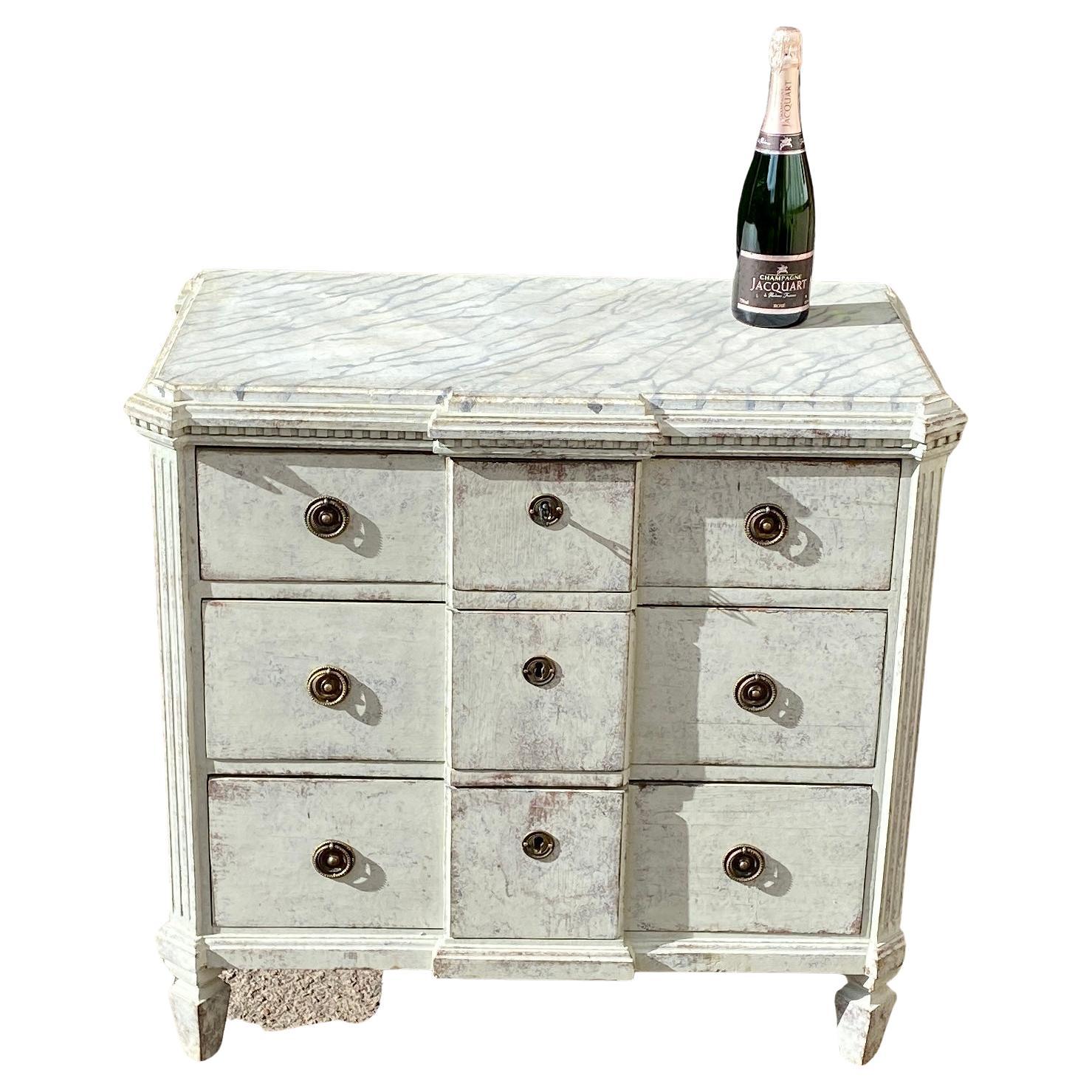 Late 19th century grey painted chest of drawers, Swedish.
This 3 drawer dresser has a charming break front style, an amazing faux marble top and the original brass hardware.