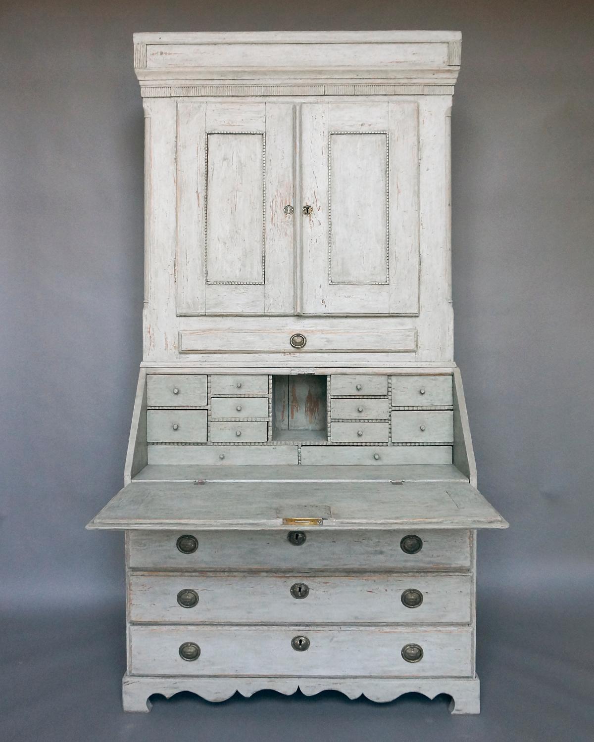 Period Gustavian secretary, Sweden circa 1790, in two parts. The upper section retains its original cornice with reeded detail at the corners over inset quarter-round columns. Below a reeded frieze are two doors with recessed panels and notched