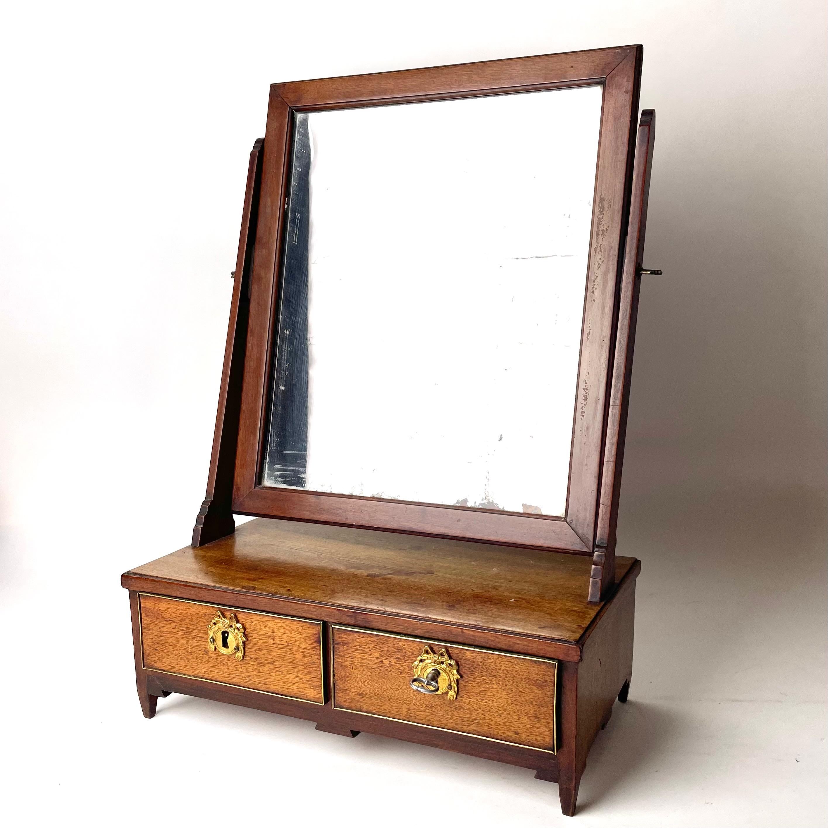 A Gustavian Shaving Mirror in Mahogany & Brass Details. Sweden 1780-1790s.

A beautiful shaving mirror in mahogany (Mahogani Swietania). Made in Sweden during the 1780s-1790s, either during the reign of King Gustav III or his son Gustav  IV. The
