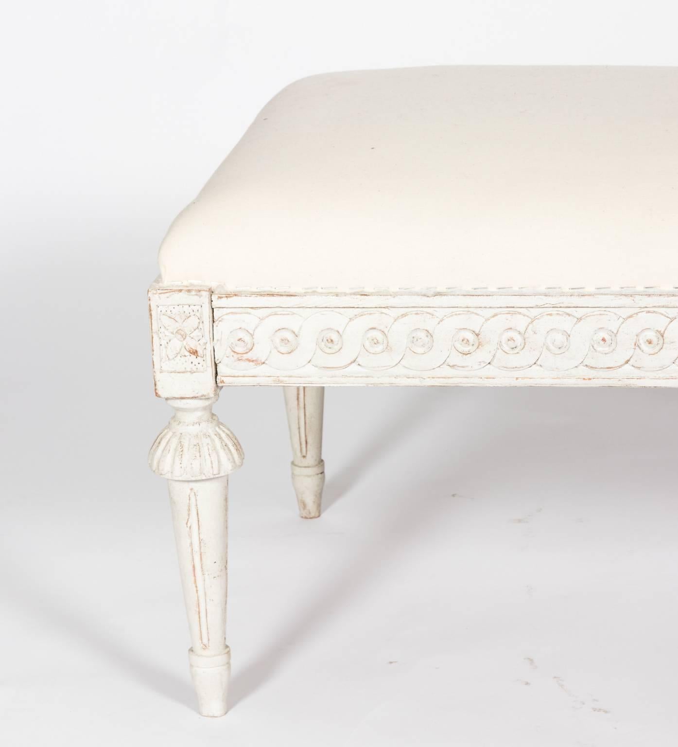 Gustavian white painted bench with guilloche trim on the seat rail and trumpet turned legs, circa early 19th century.
 