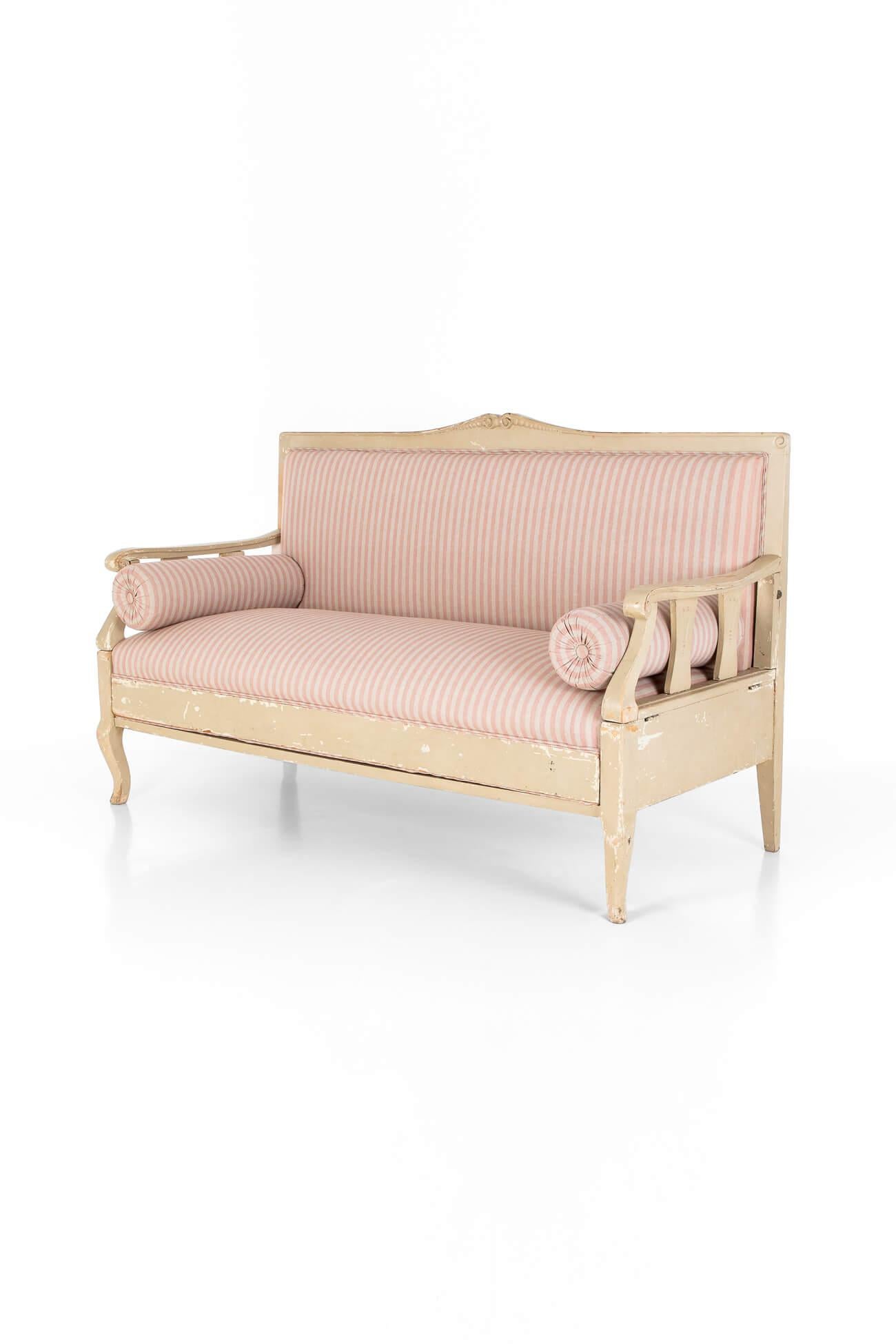 A wonderful Swedish sofa in Gustavian style made of Scots Pine.

The seat ends collapse, allowing the bench to fold down into a flatbed, which extends the length of the sofa and provides a comfortable sleeping option for guests.

It has been