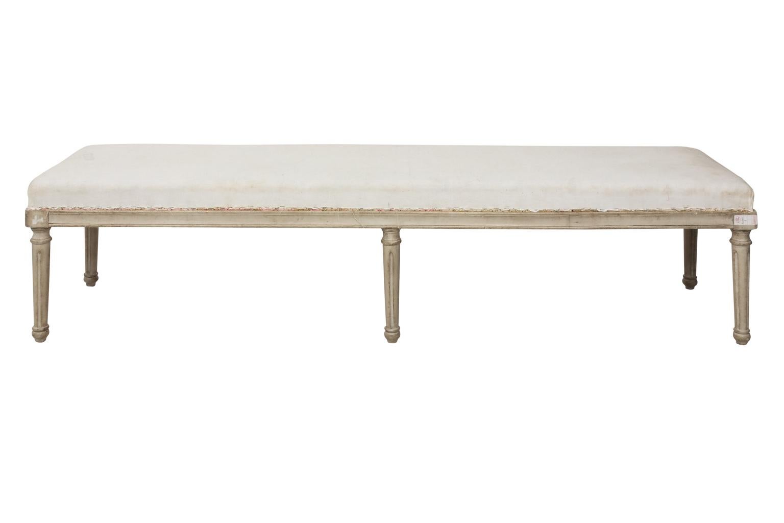 White painted Gustavian style bench with six round, fluted legs and carved rosettes.
 