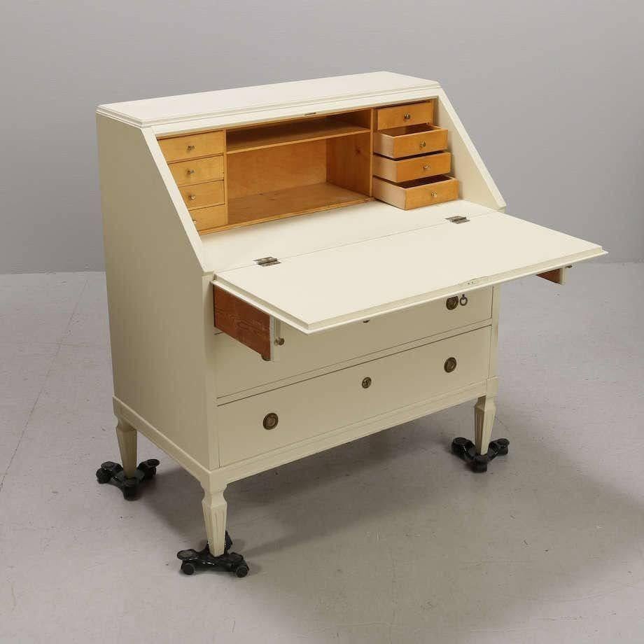 Cream painted secretary with the fluted legs and graceful lines quintessential of the Gustavian style. Early 1900s, later painted, original brass hardware. Fold out desktop with 8 interior drawers for storage.
 
H 40