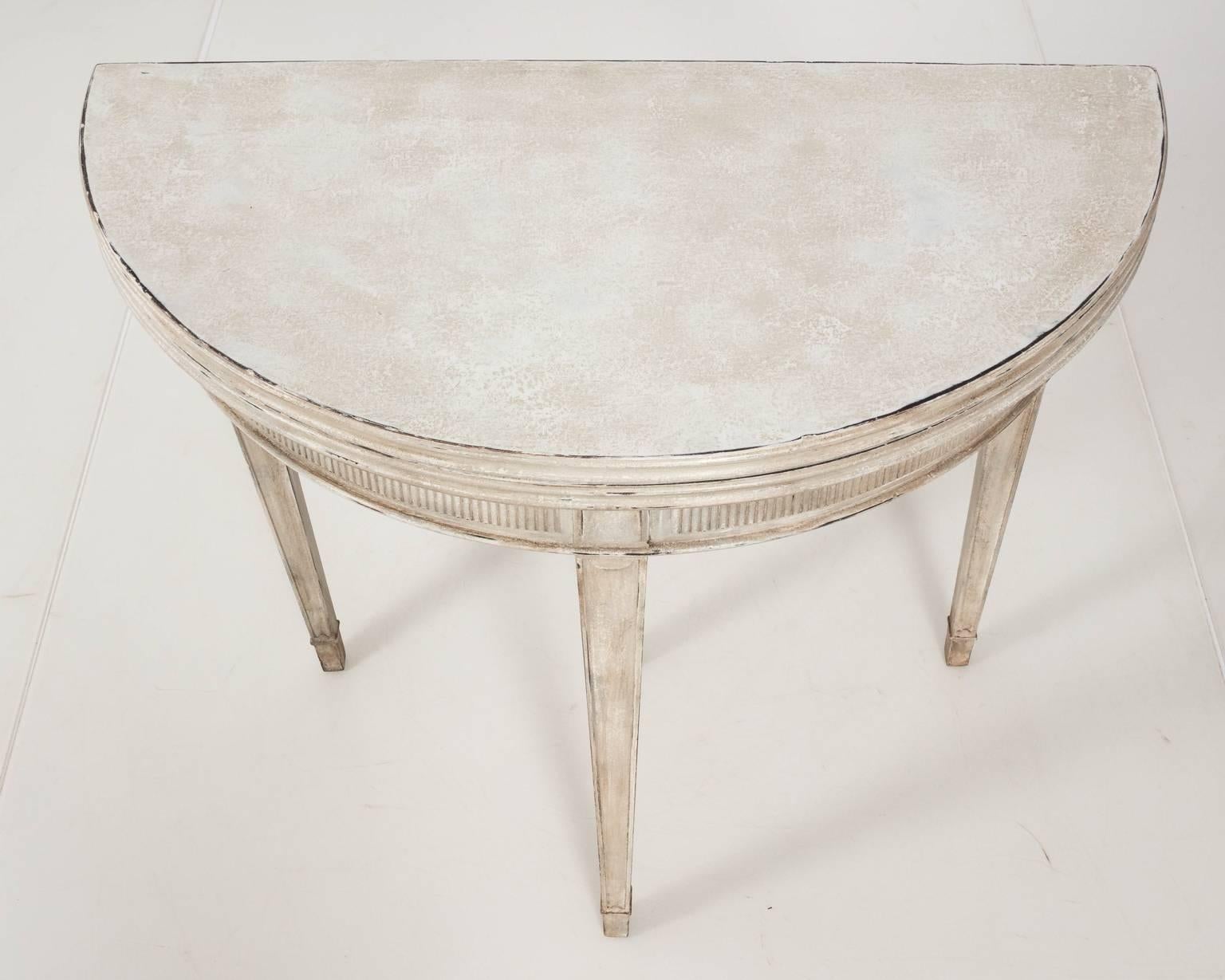 Gustavian style grey painted flip-top demilune table that opens to a 31.00 inch round diameter, circa 1940s.