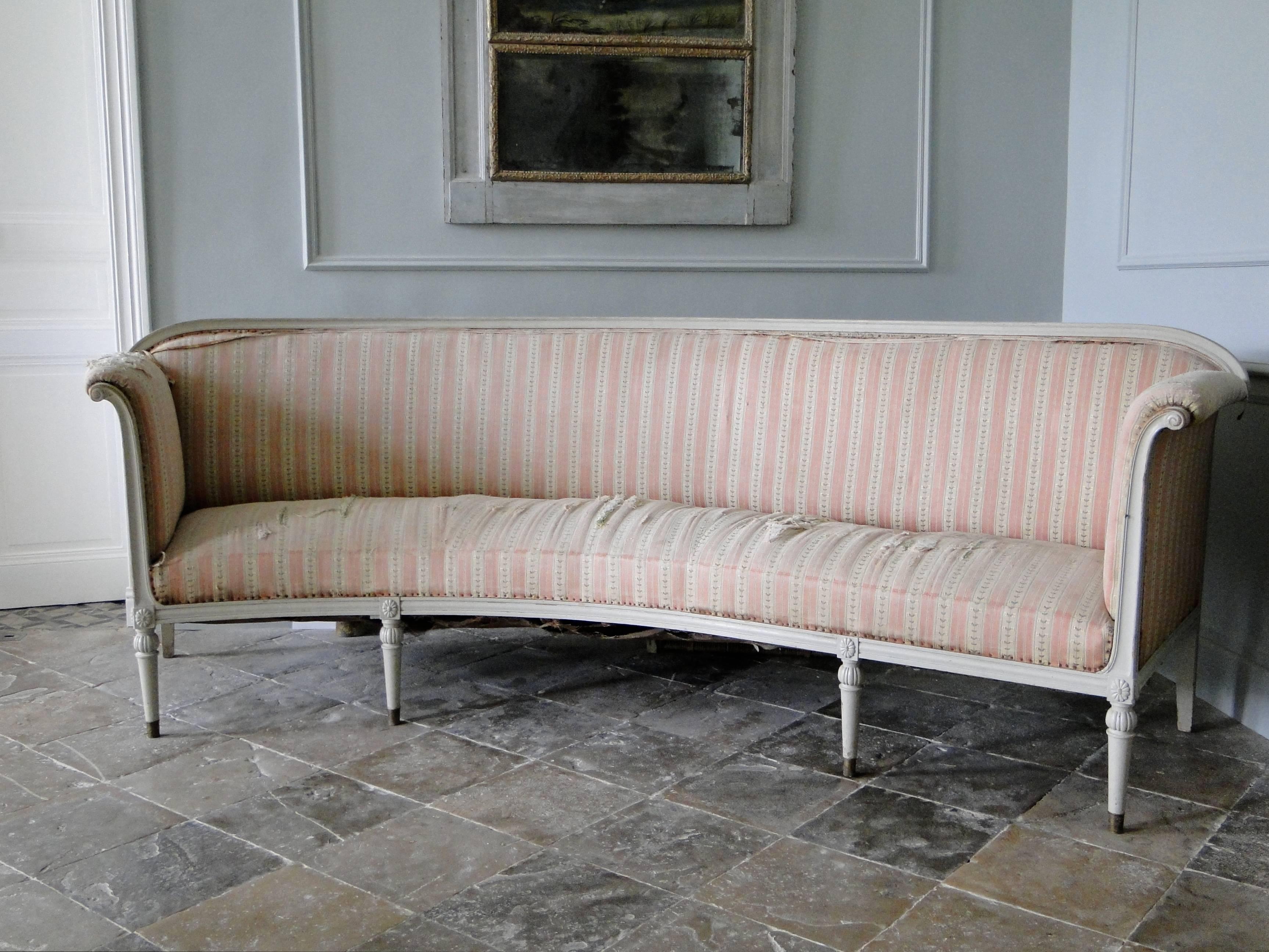 Grey painted Gustavian sofa, woodcut decor. Total length approx. 293 cm, 110cm on right side is straight, the rest is curved. Seat height 50cm. The sofa has to be upholstered it is in its original condition, and has a very special form, partly