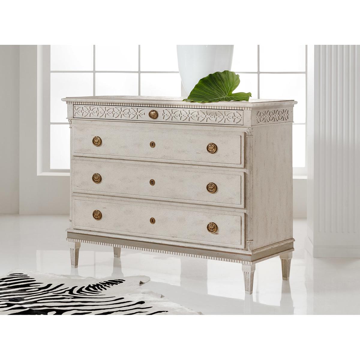 Gustavian Style Swedish Dresser, large four-drawer commode with an antique painted finish, with carved dental moldings, blind fret carings, with large long drawers, brass ring pull hardware and raised on square tapered fluted legs. After the 19th