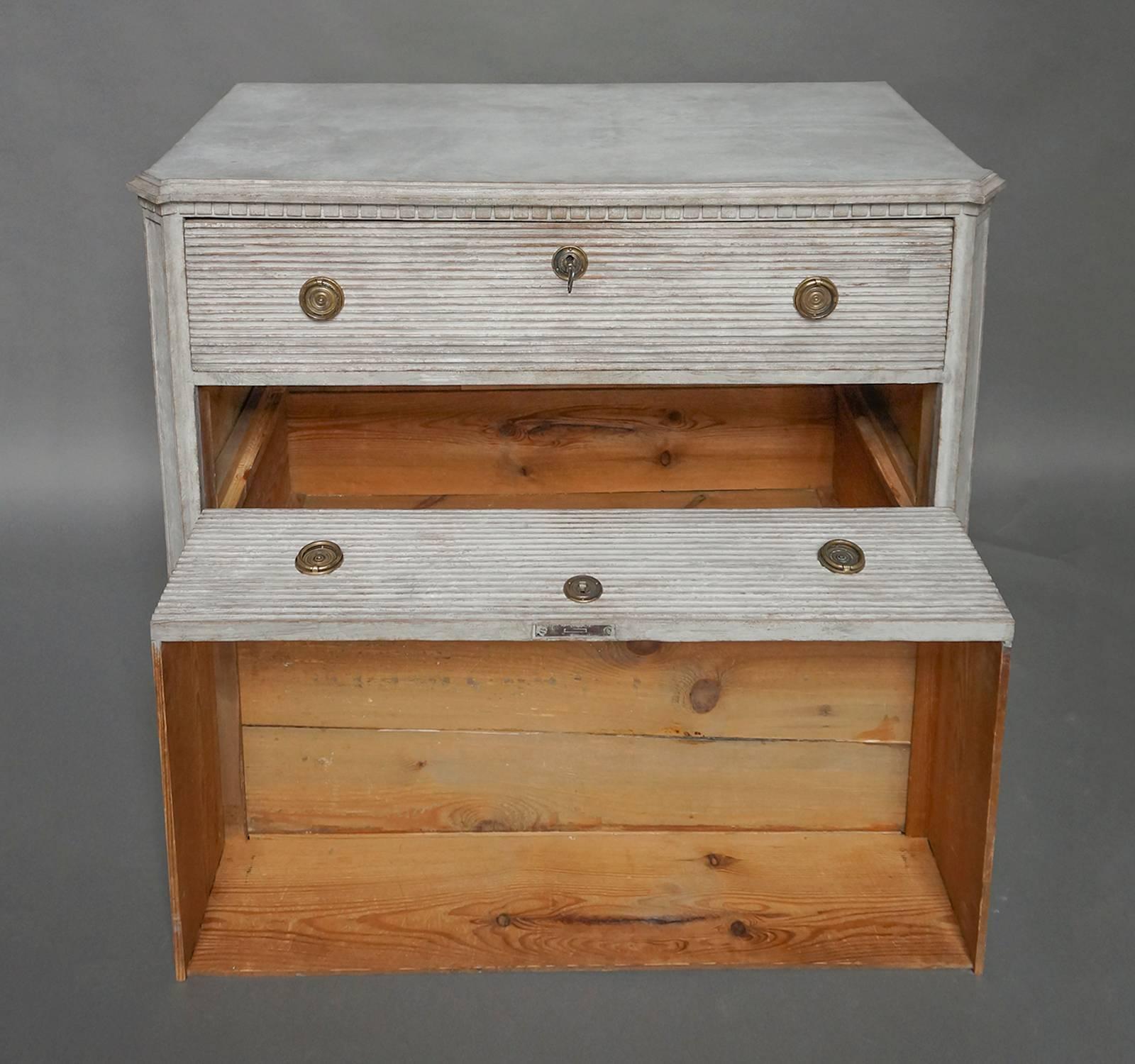 Swedish chest of drawers, circa 1850 in the Gustavian style. The three drawers have full-width horizontal reeding, and the canted corner posts feature recessed panels. Shaped top and tapering square feet.