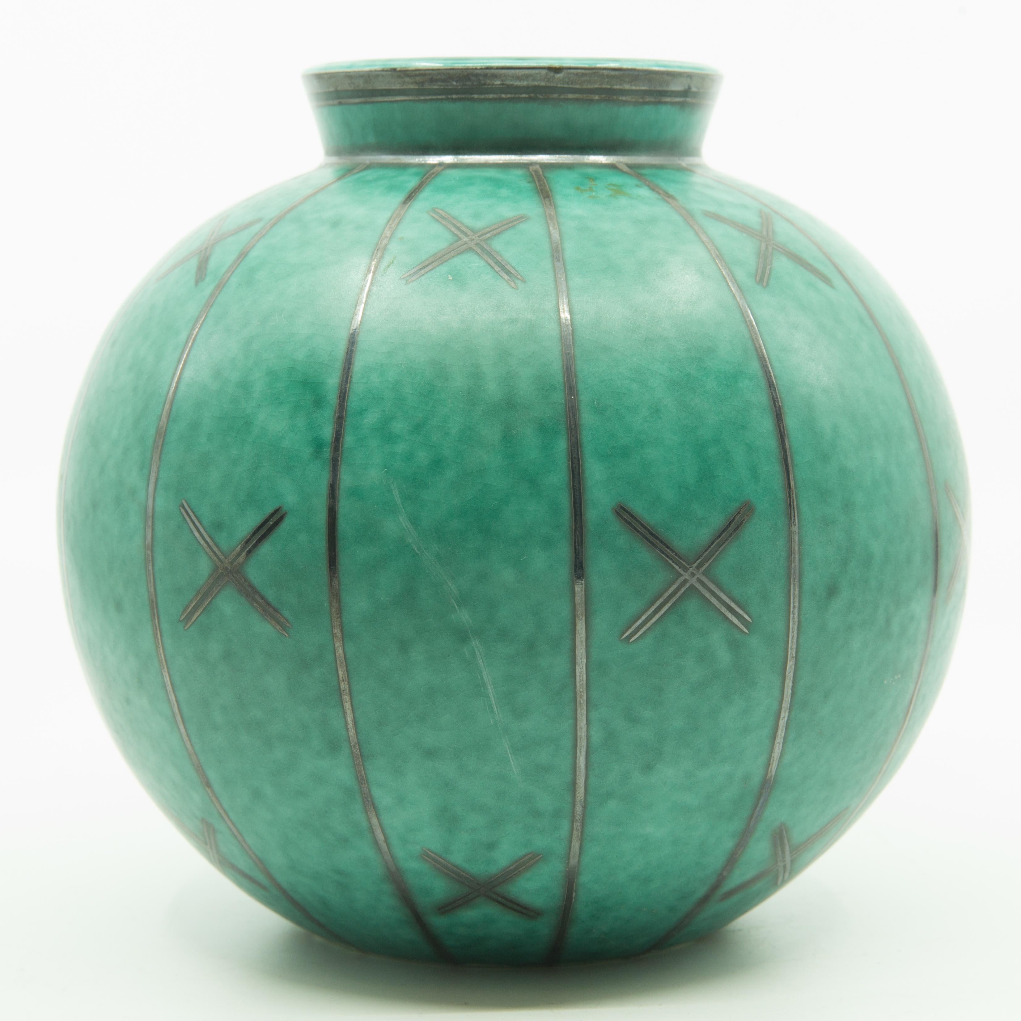 Offered is a fine example of 1930s midcentury/art deco Gustavsberg’s Argenta art pottery. The vase is eimbelished with real silver overlay and depicts a geometric art deco motif. The vase was designed by Wilhelm Kage. Algot Wilhelm Kage was a