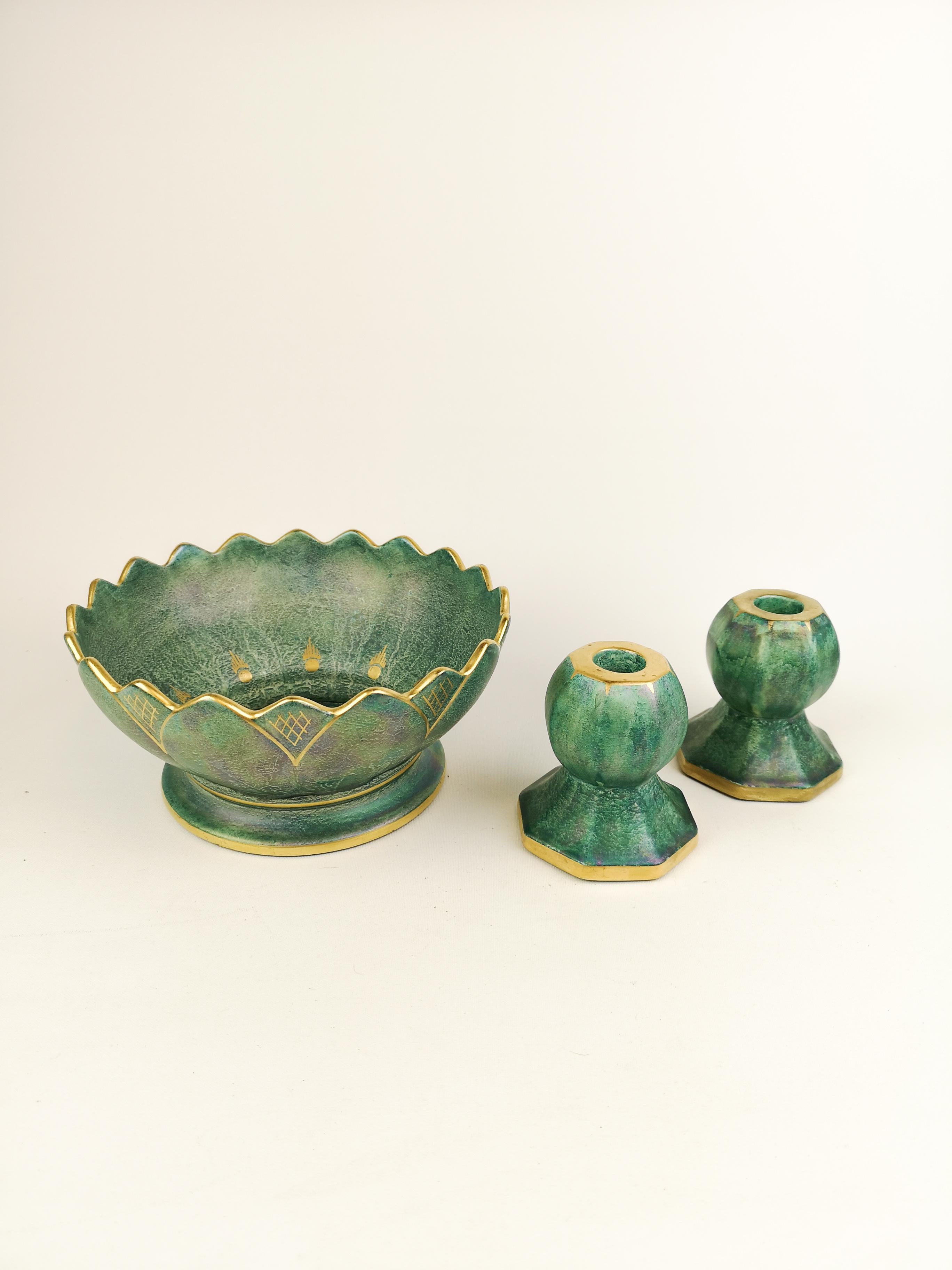 A wonderful bowl and candlesticks created by Josef Ekberg and manufactured by Gustavsberg Sweden in 1920s. Wonderful green glaze with hand painted gold pattern on the bowl and Candlesticks. 

Measures: Bowl 21 cm D/ 11 cm H Candlesticks 10 cm H /