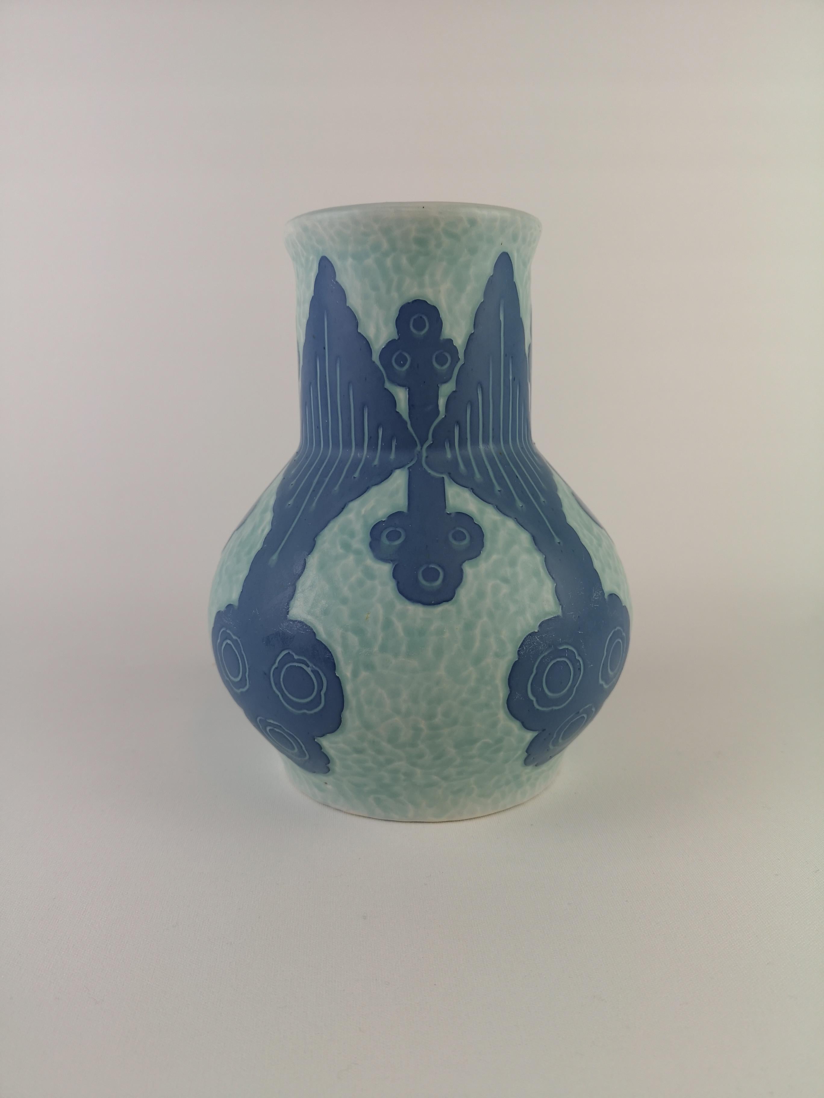 Sgraffito vase decorated with a floral motif, by Josef Ekberg for Gustavsberg.
Sgraffito is a way of combinding two layers into a pattern, the second layer is scrapt of and left is a light blue background with a beautiful pattern on top.

Signed
