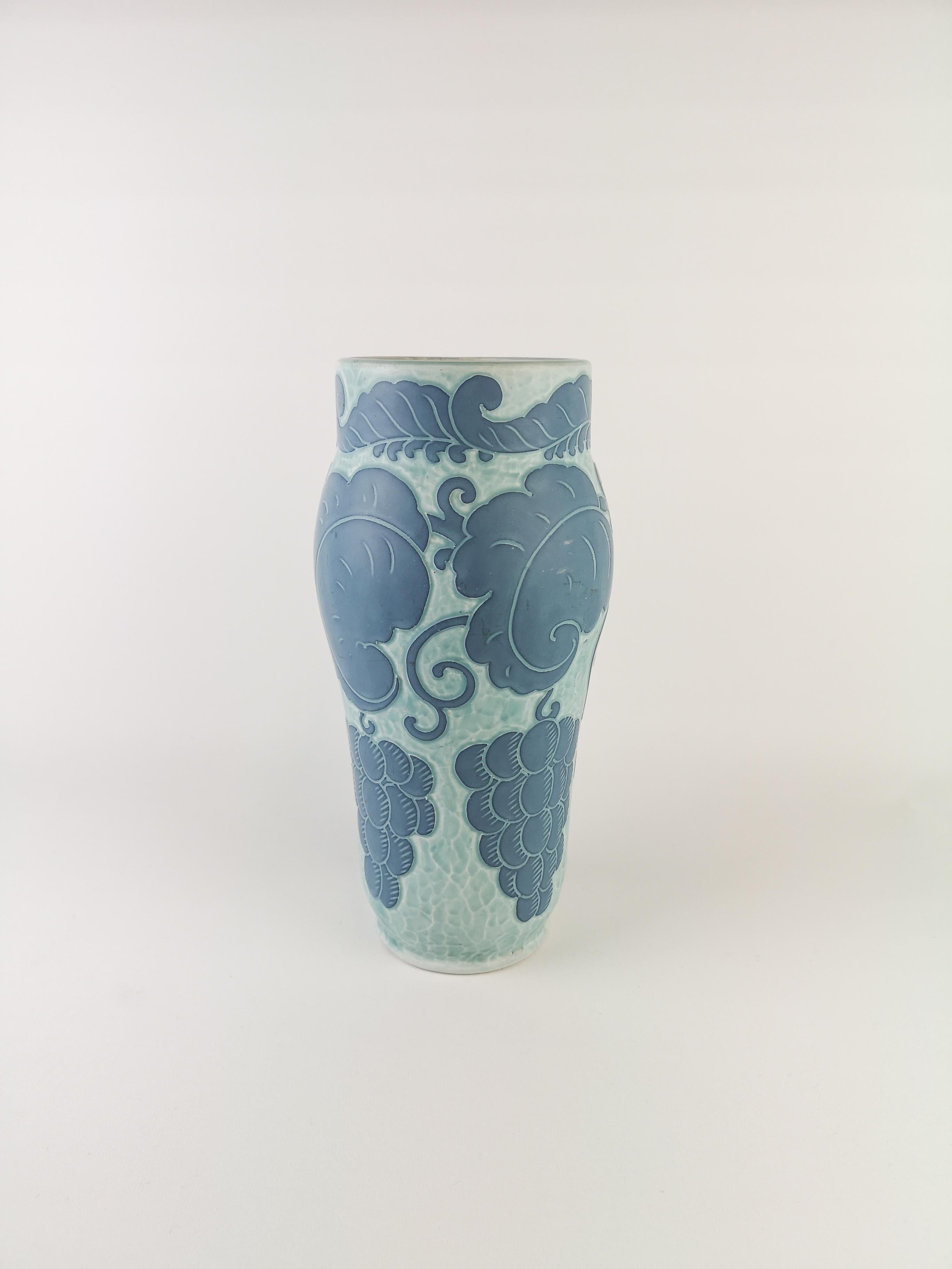Sgraffito vase decorated with a floral motif, by Josef Ekberg for Gustavsberg.
Sgraffito is a way of combining two layers into a pattern, the second layer is scrapt of and left is a light blue background with a beautiful pattern on top.

Signed